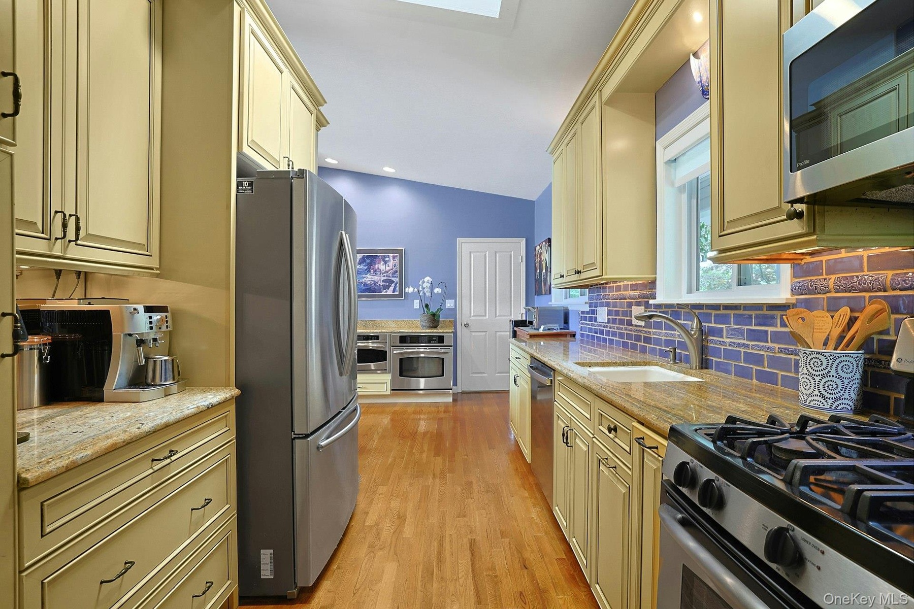 A beautifully appointed chef's kitchen featuring stainless steel appliances: 4 ovens including a range with upper and lower oven, a Trivection oven, a