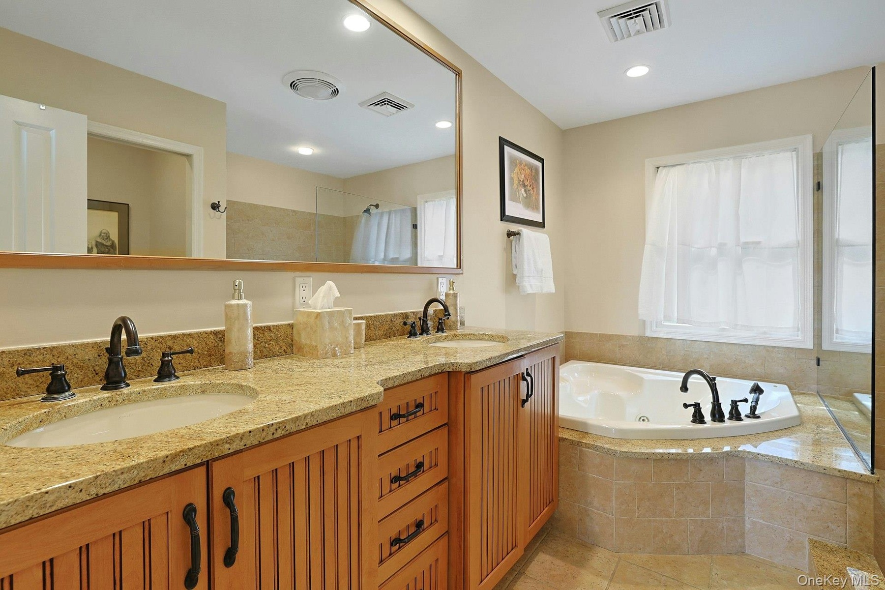 Unwind in the gorgeous en suite primary bathroom, featuring a double vanity and a relaxing Jacuzzi tub—the perfect place to end the day.