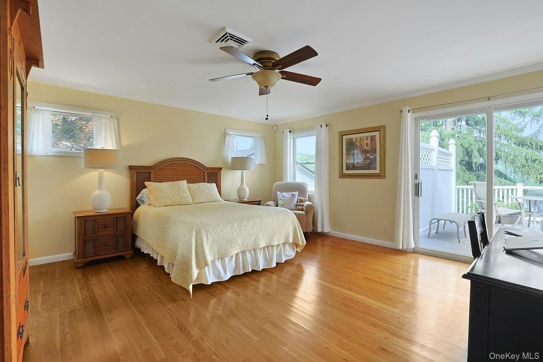 Wake up to breathtaking lake views in the spacious primary bedroom, complete with a sliding glass door that opens to the deck