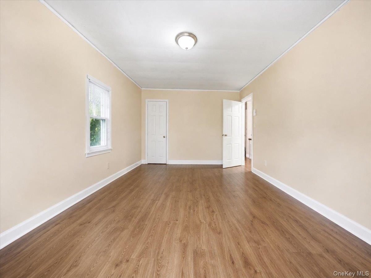 Wood-finish flooring, neutral wall tones, white trim, and a ceiling-mounted light fixture