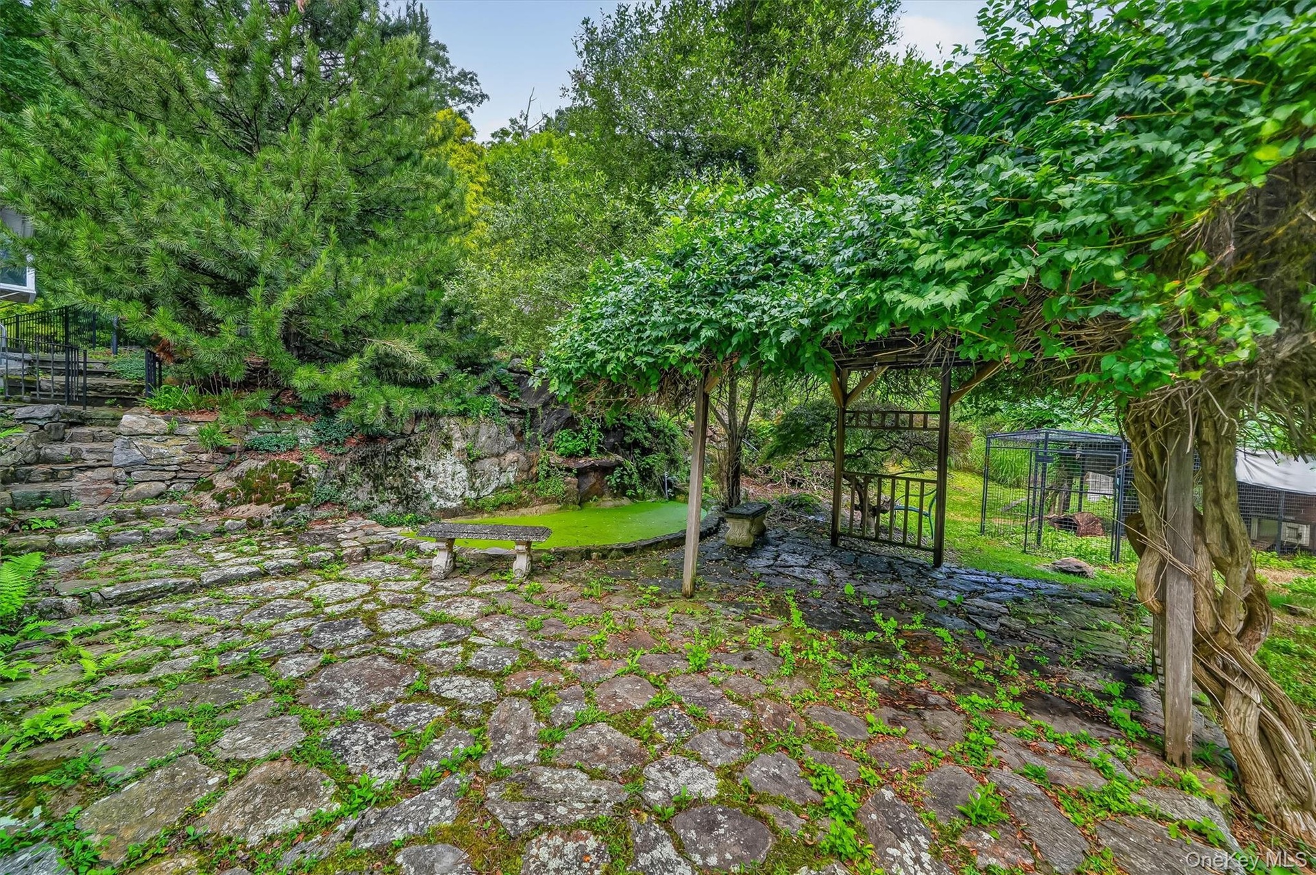 Stone paver patio with natural rock retaining wall
