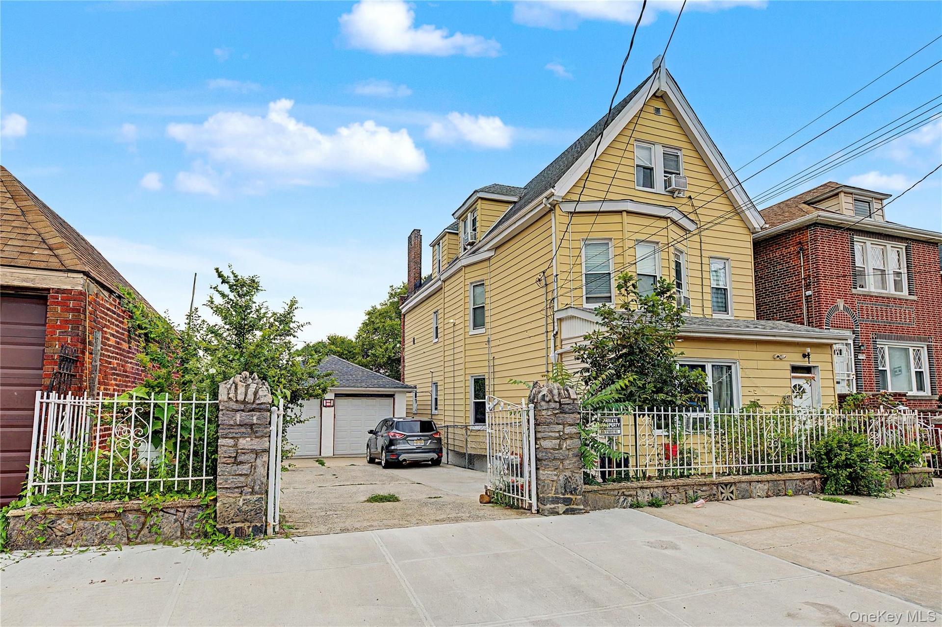 Side exterior highlighting the expansive private driveway and detached two-car garage.