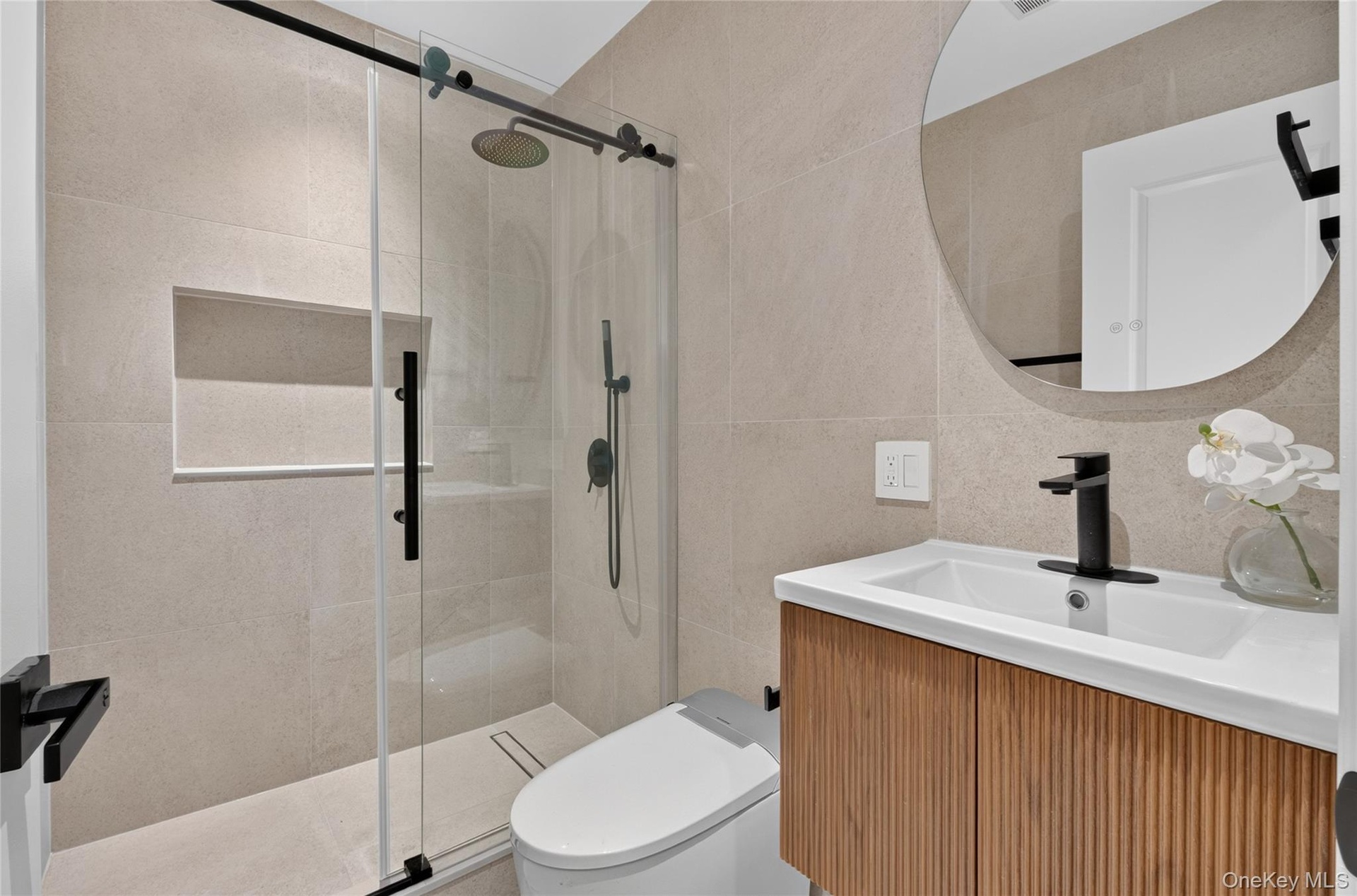 Frameless glass shower enclosure with matte black hardware