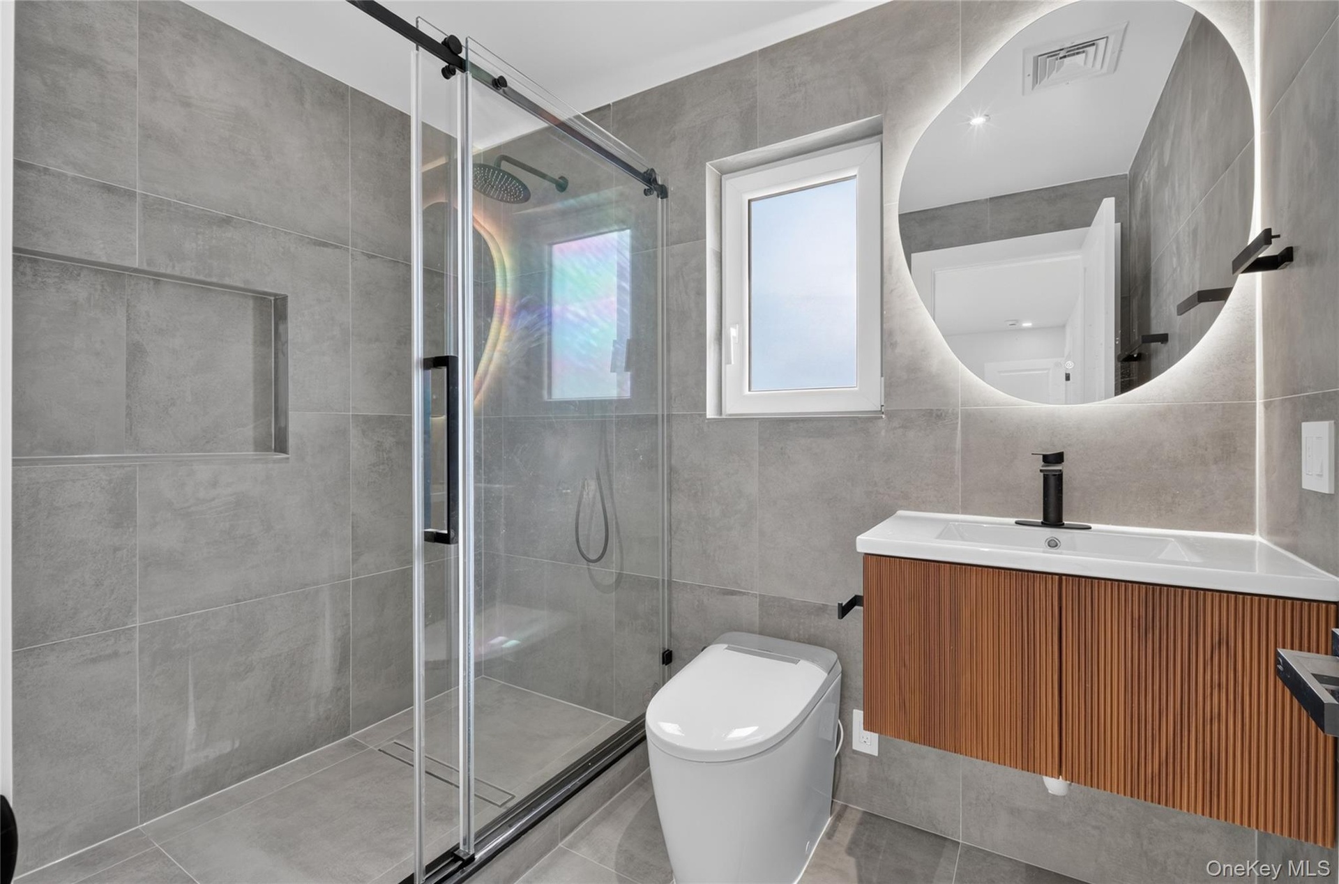 Shower with glass sliding door, built-in shower niche, and rain shower head