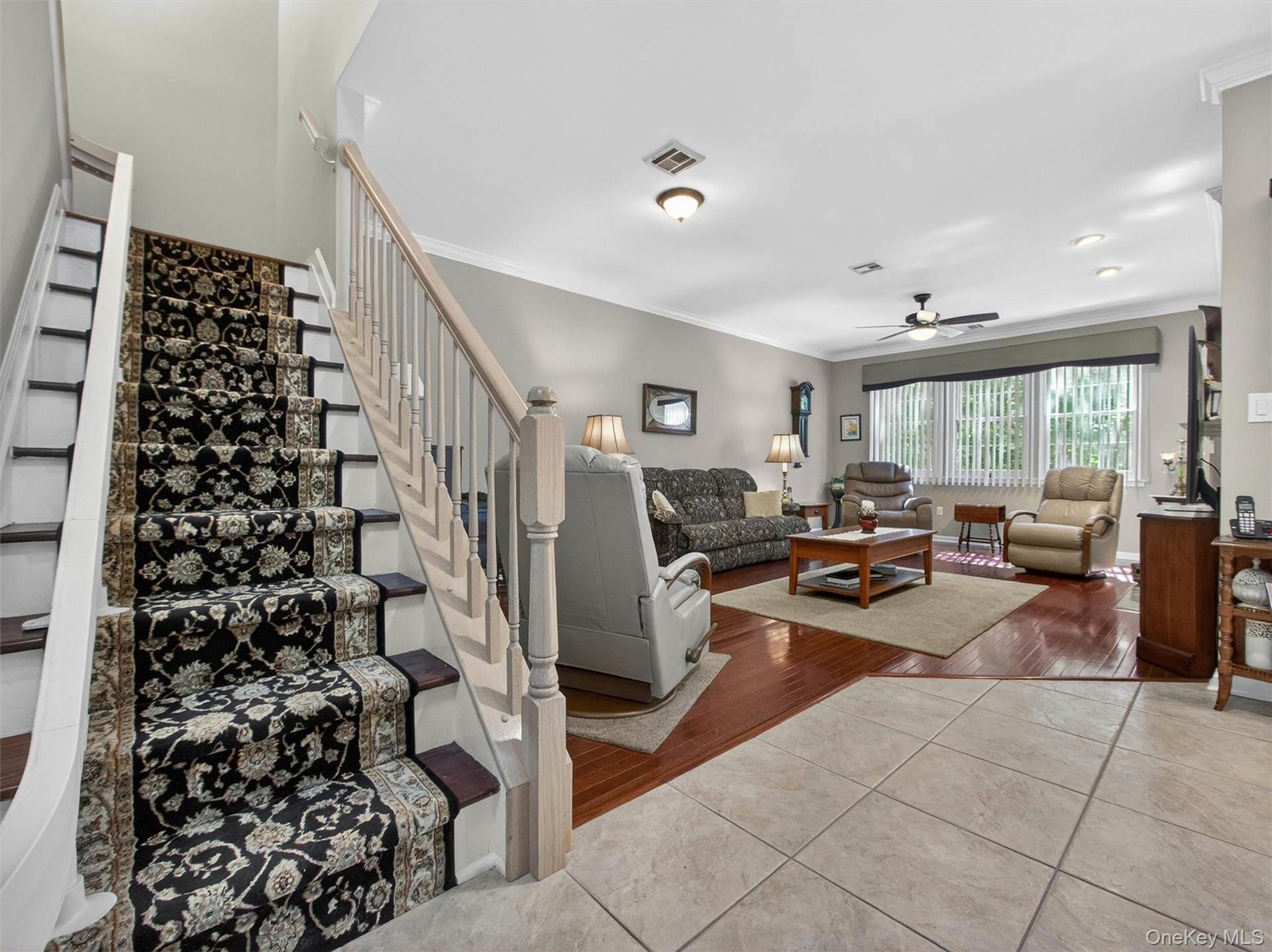 View from the entry foyer thru to the living room and stairs leading to bedroom level.