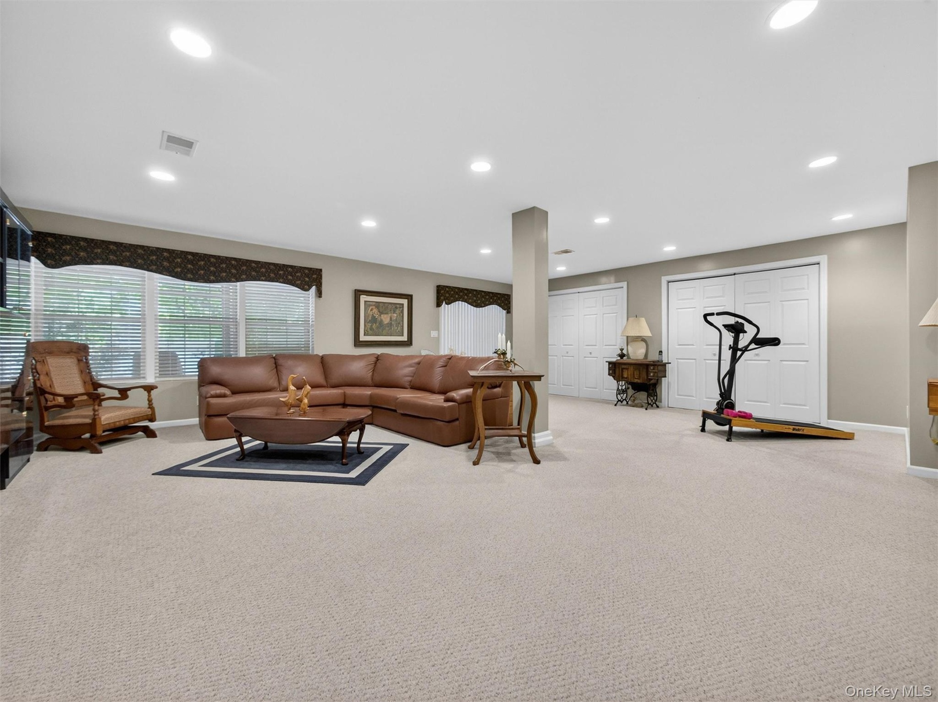 Beautiful basement with full-sized windows, multiple large closets, recessed lighting, all neutral carpeting and slider to a covered patio.