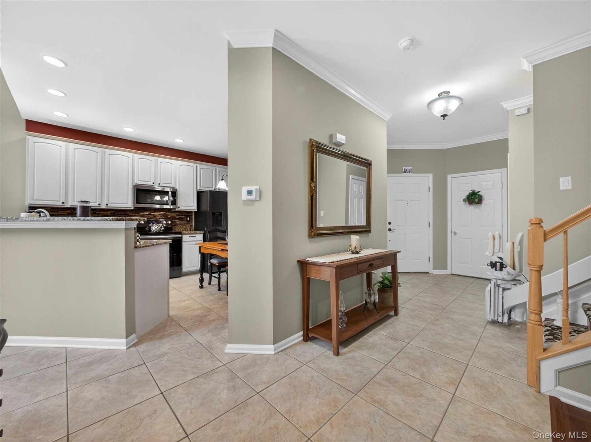 View to the entryway foyer and garage access.  Open-plan kitchen to the left.