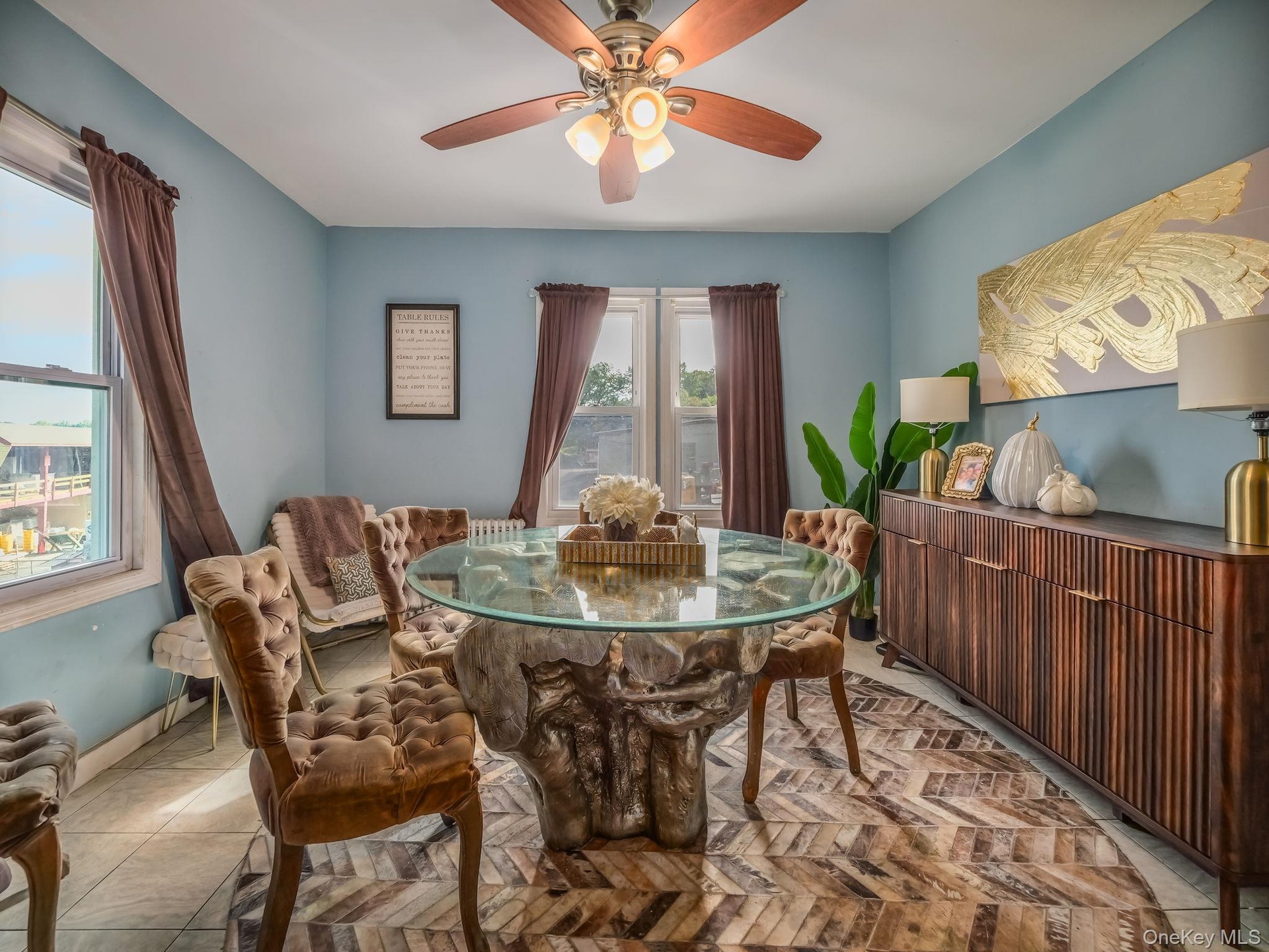 Tiled dining area with ceiling fan and baseboards