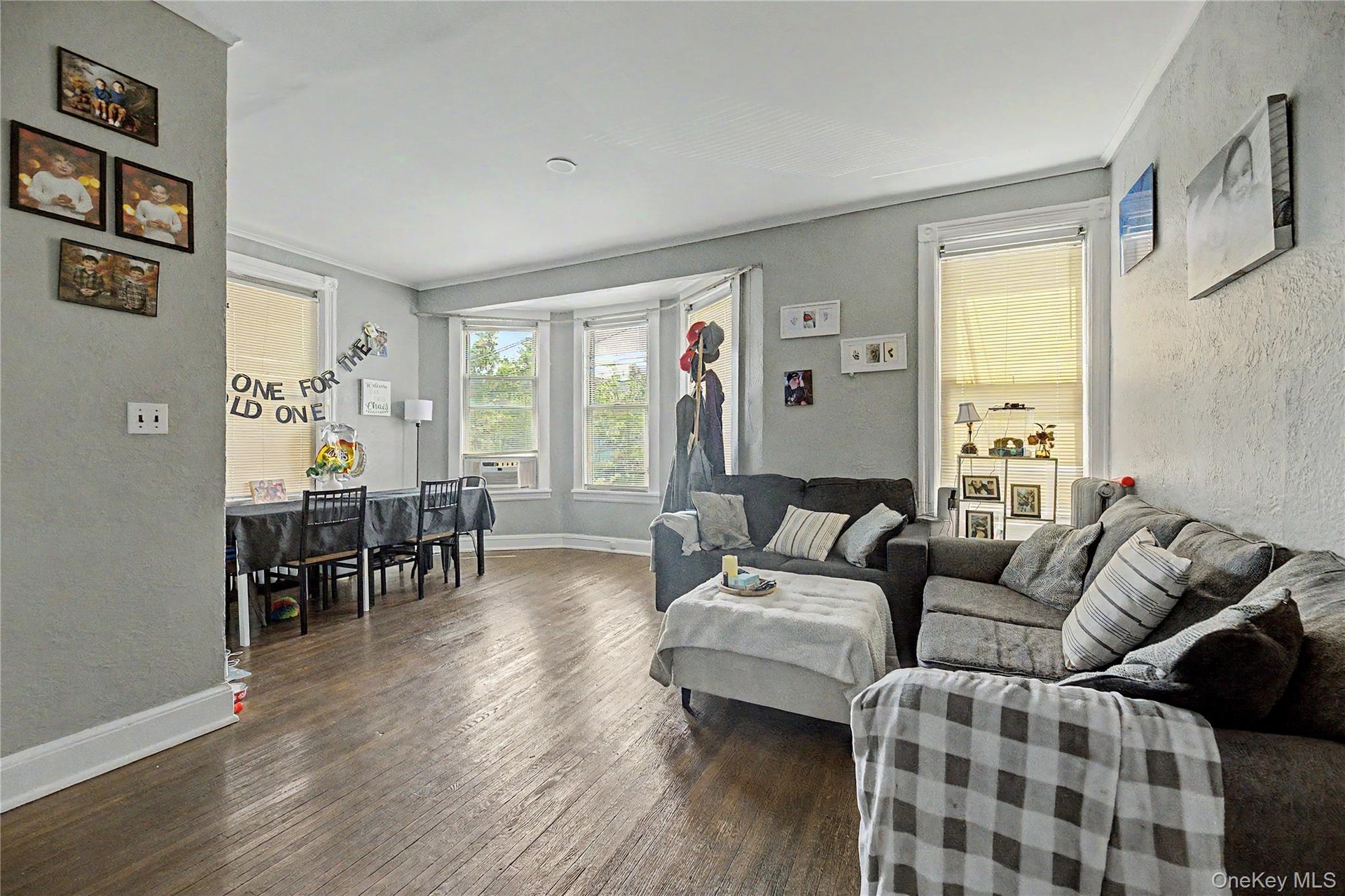 Hardwood flooring throughout, multiple windows, and crown molding