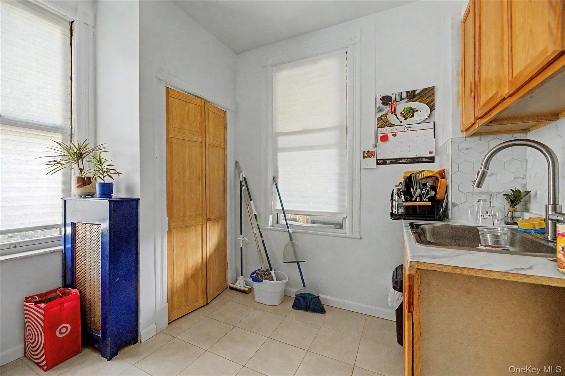White walls with a window, stainless steel refrigerator, and stainless steel range