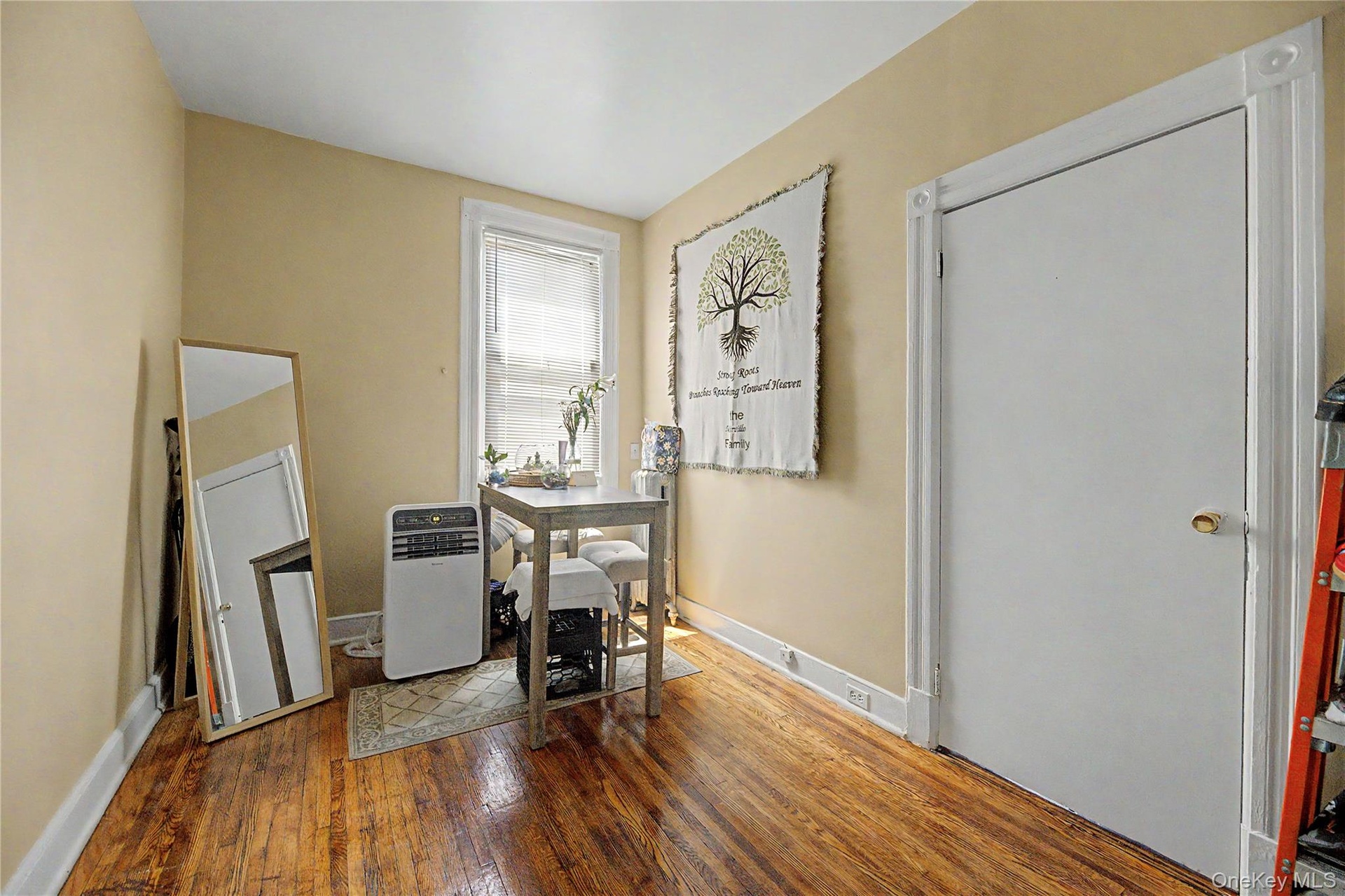 Sloped ceiling room featuring wood-finish flooring, a double window, and a flush-mount light fixture