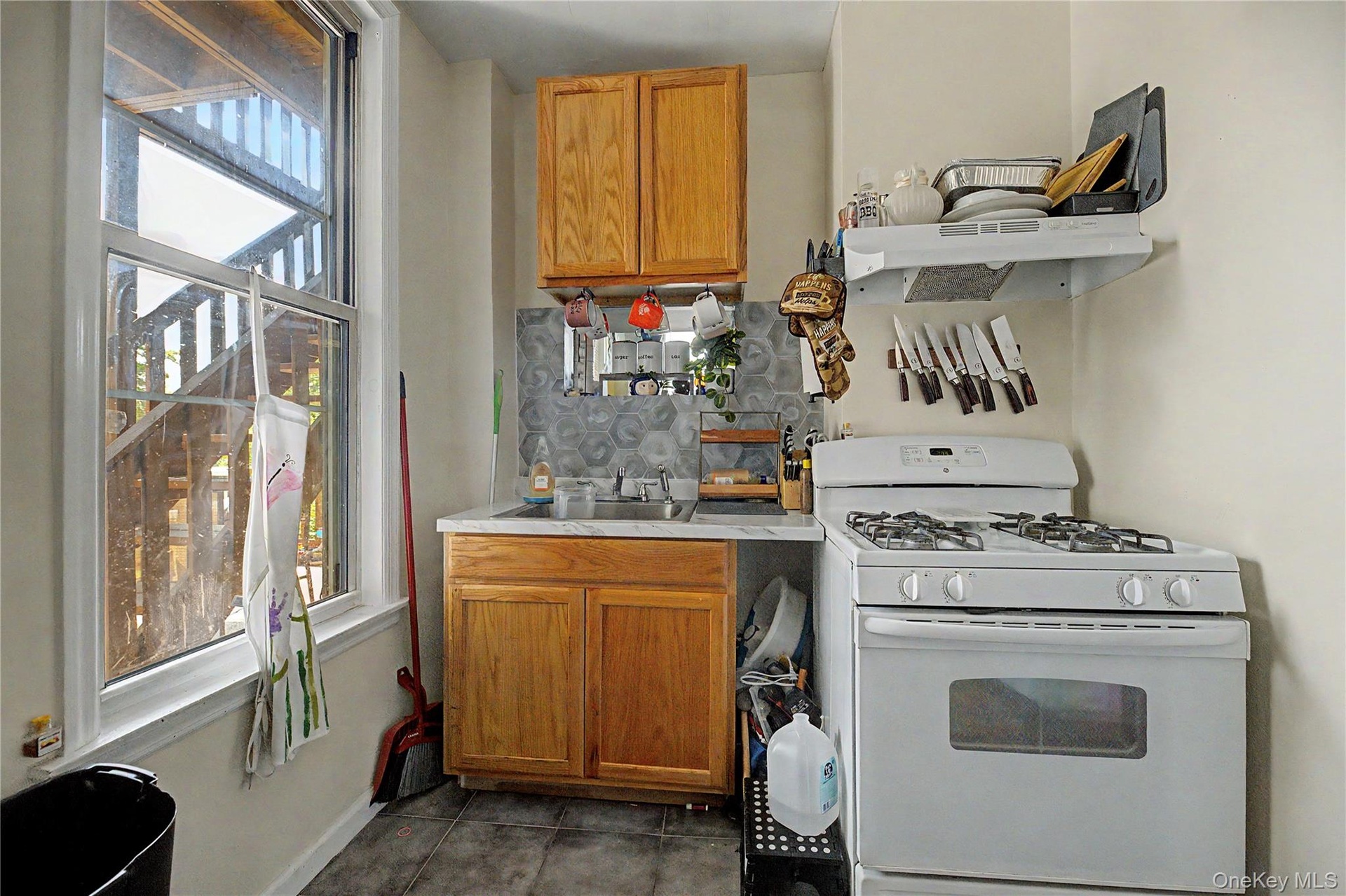 White walls with a window, stainless steel refrigerator, and stainless steel range