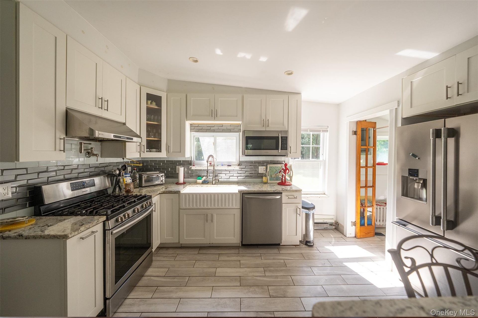 New kitchen layout with timeless finishes makes this a bright kitchen that catches the afternoon light over the kitchen sink.