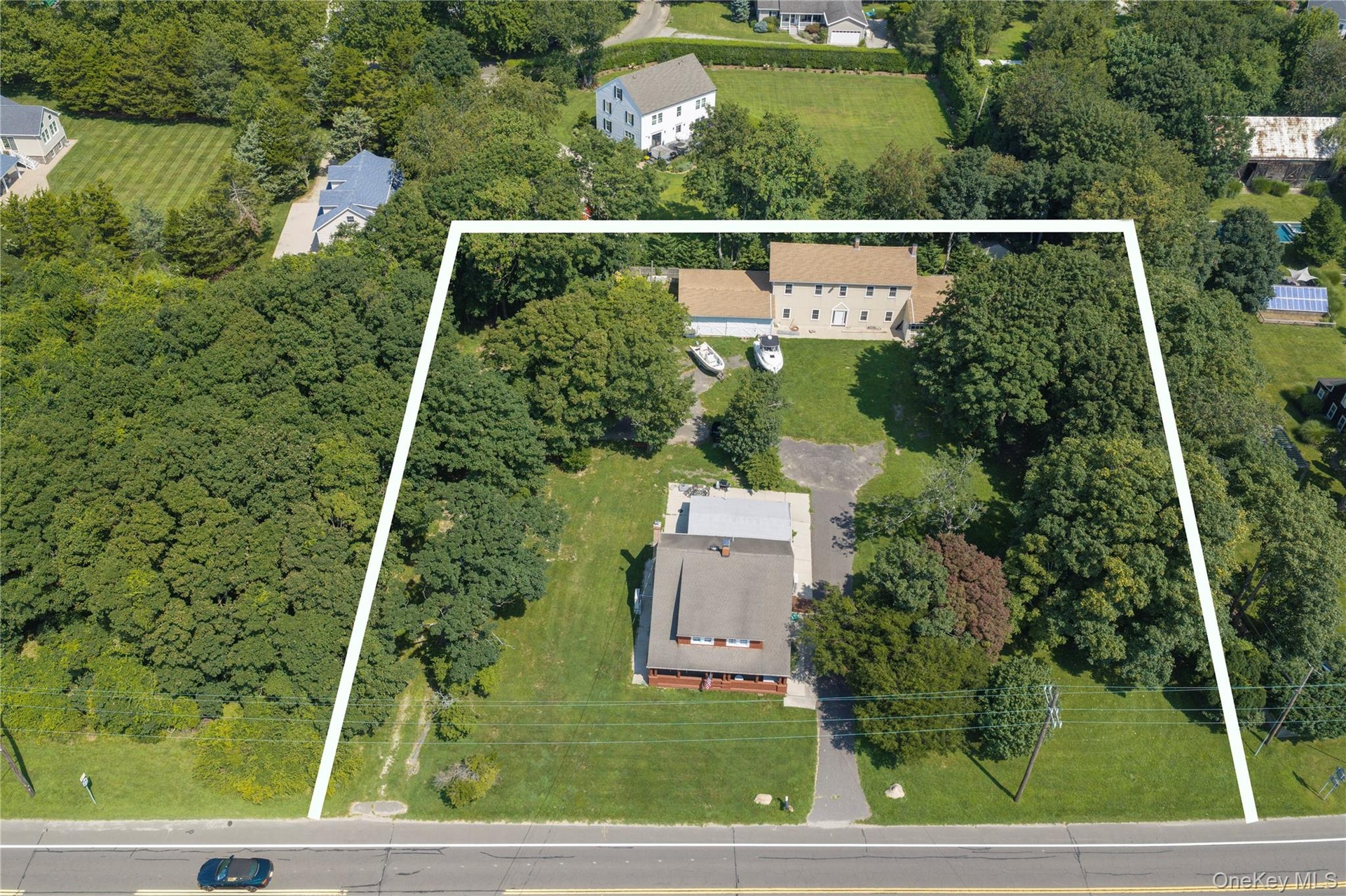 Front view of the Craftsman home renovation in 1920 with historic barn and garage in the backyard. The land to the left is preserved and will not be b
