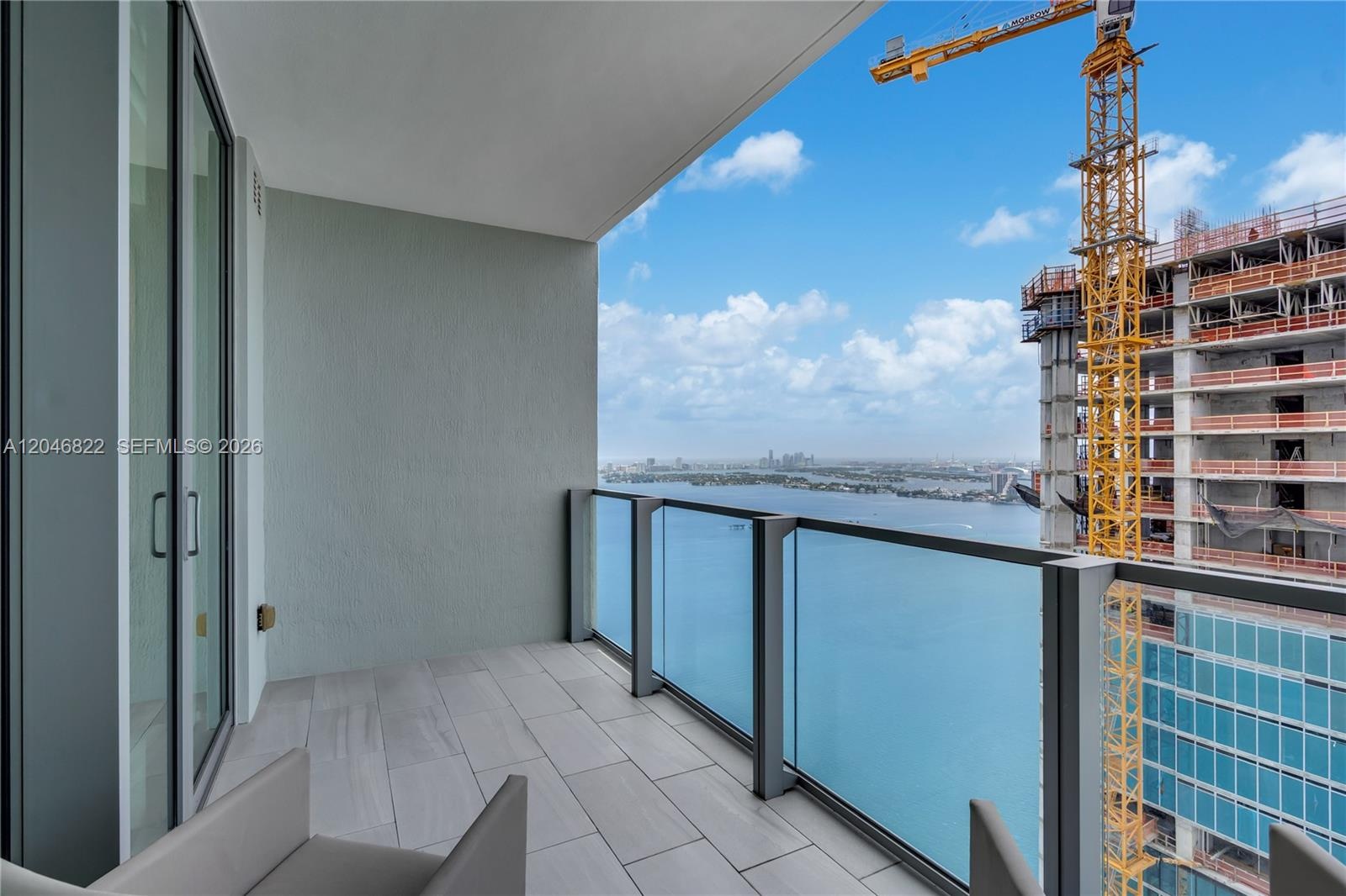 Private glass-railed terrace with open city and water views