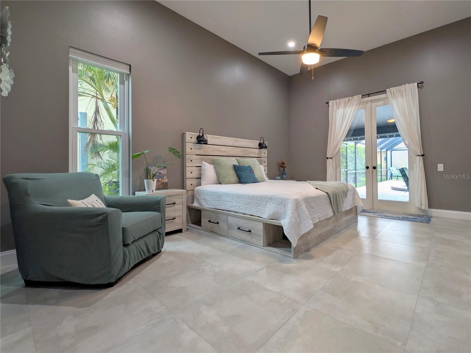 Primary Bedroom w/ french doors leading out to pool.