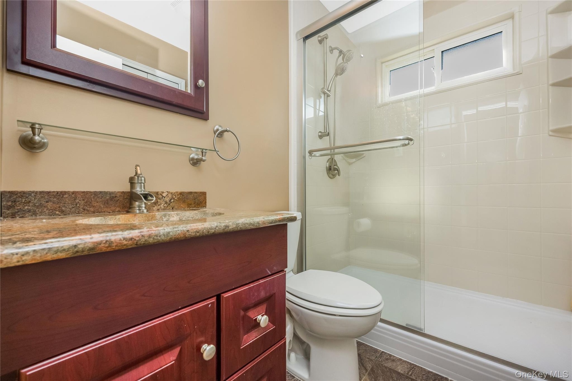 Wood-finish vanity with a stone countertop and an integrated sink