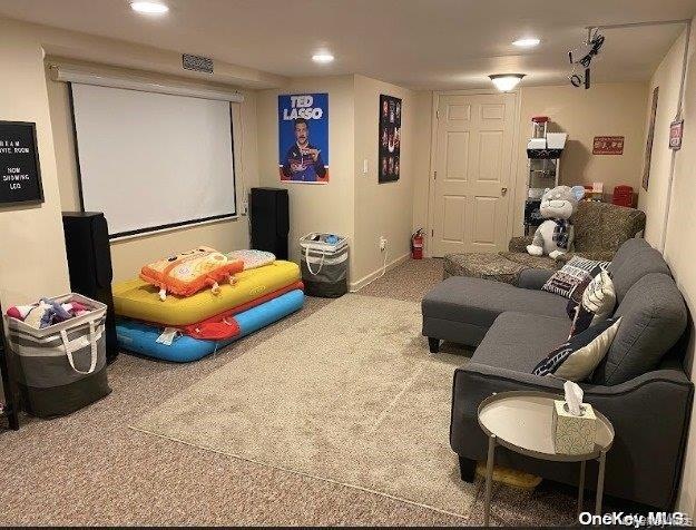 Carpeted cinema room with recessed lighting