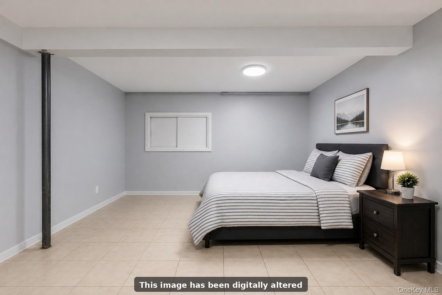 Spacious basement guest room featuring neutral gray walls, recessed ceiling lighting, and light wood-finish flooring.