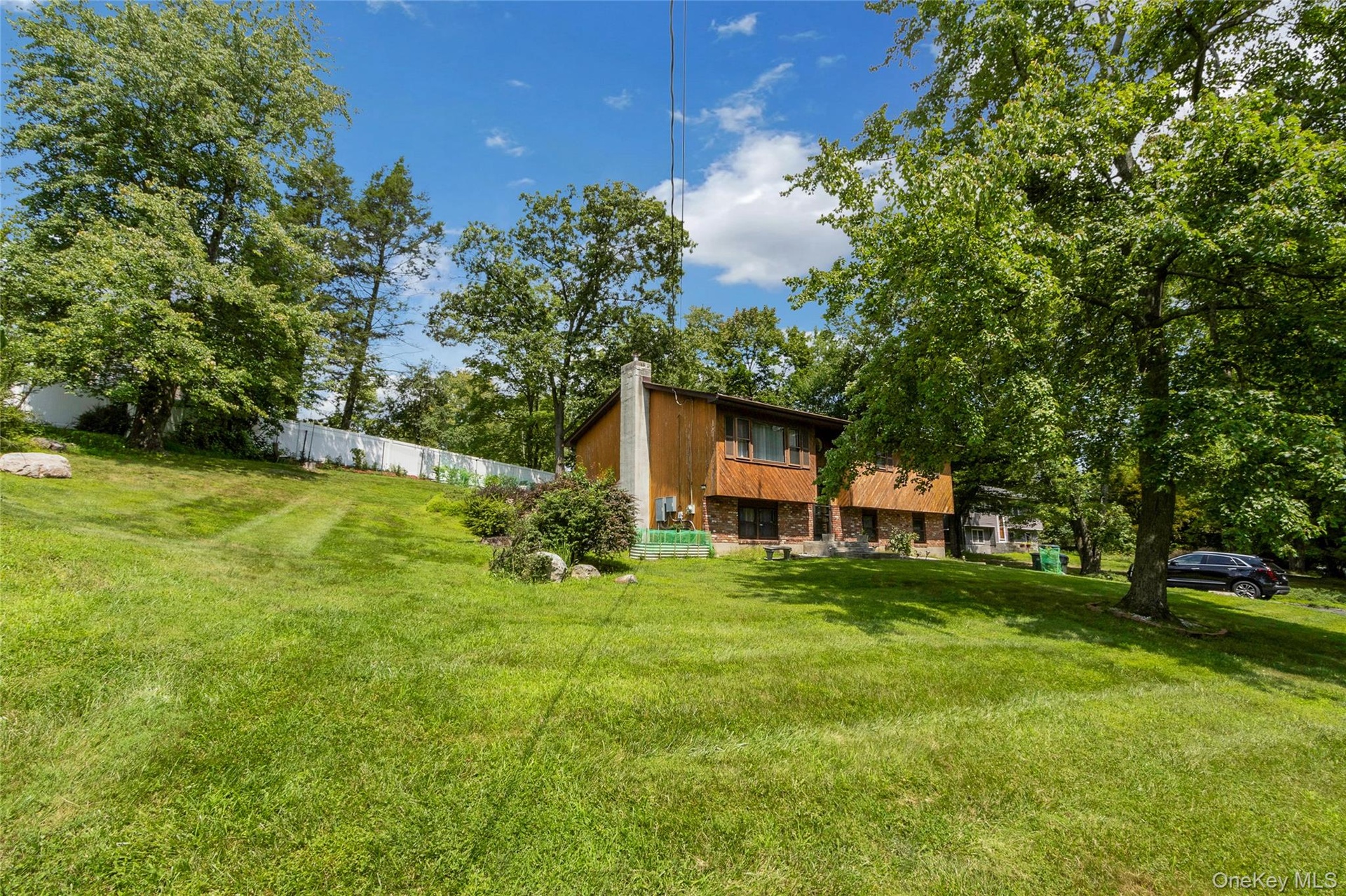 Note the white fence along the property line flanked by newly planted trees