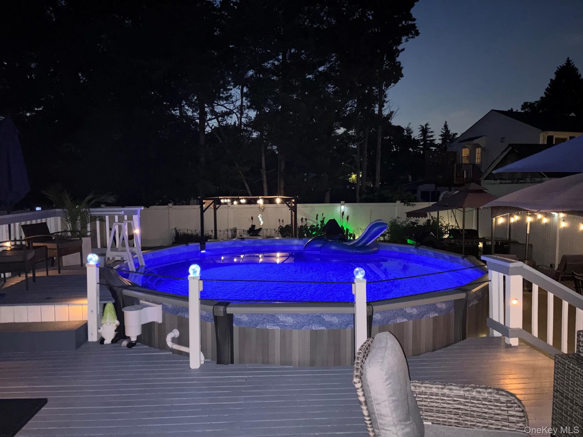 Backyard featuring a built-in pool, expansive multi-level decking, and perimeter fencing