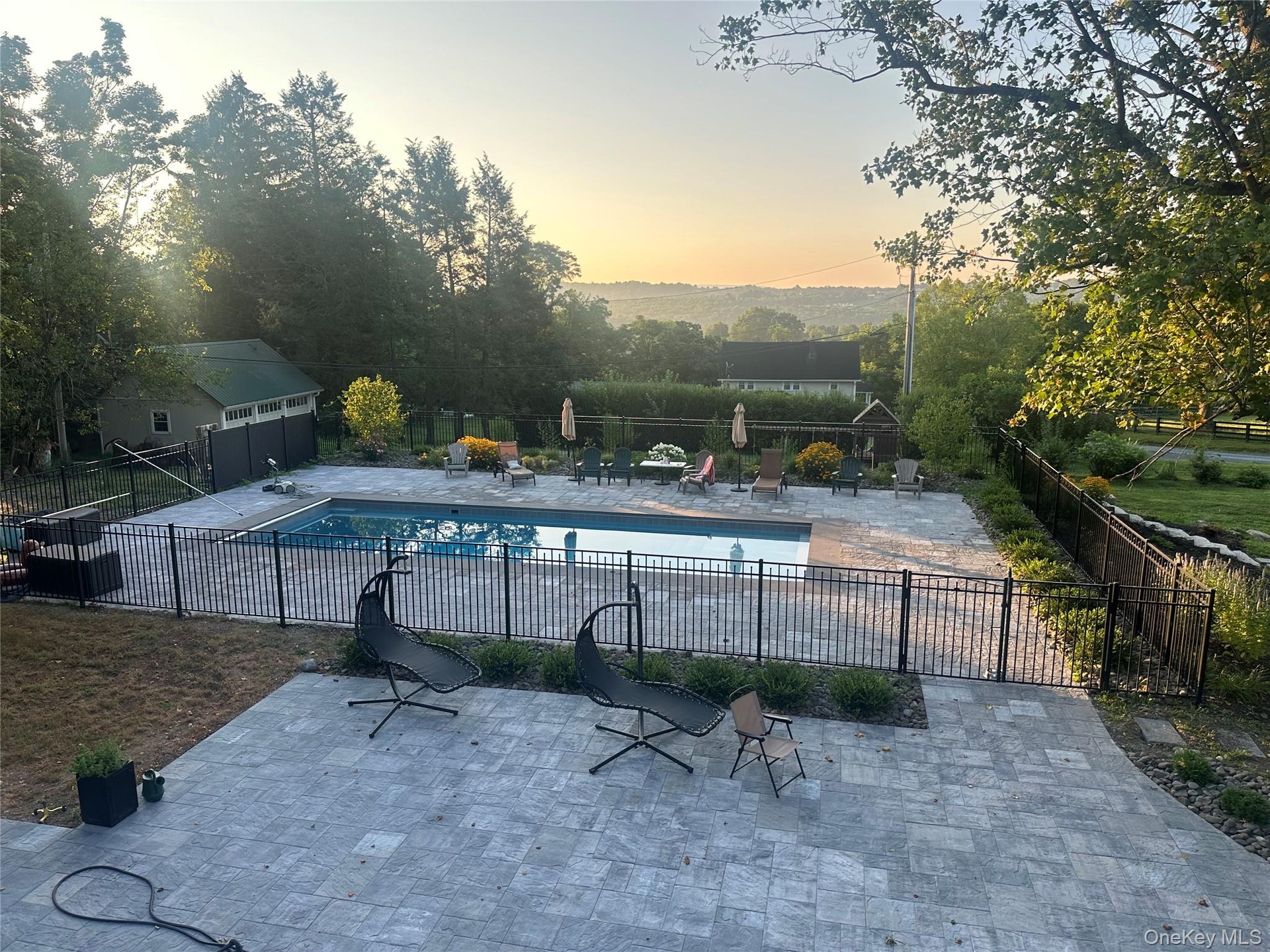 Pool at dusk featuring a patio and a community pool