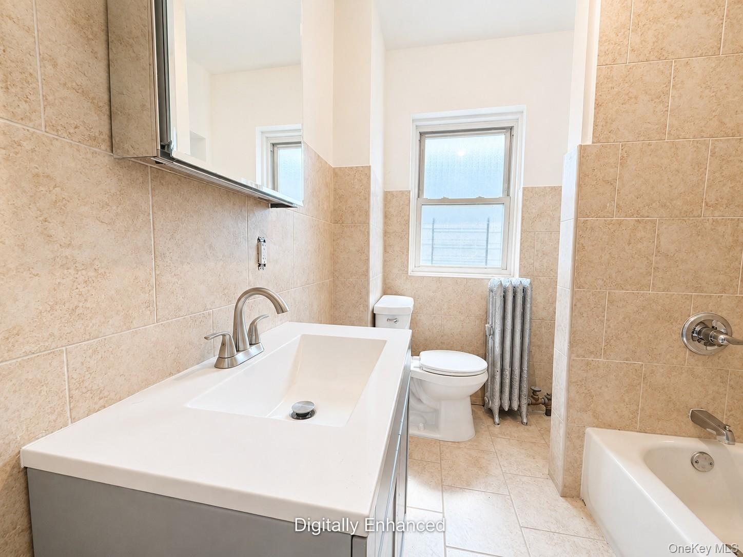 2nd fl Vanity with integrated sink, modern brushed nickel faucet, wall-mounted mirrored medicine cabinet, bathtub with shower fixture, and tiled walls