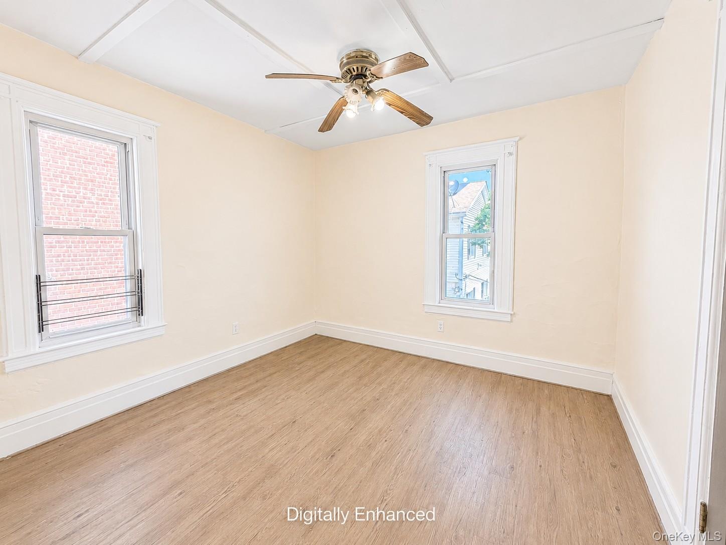 2nd fl room featuring wood-finish flooring and two windows with white trim