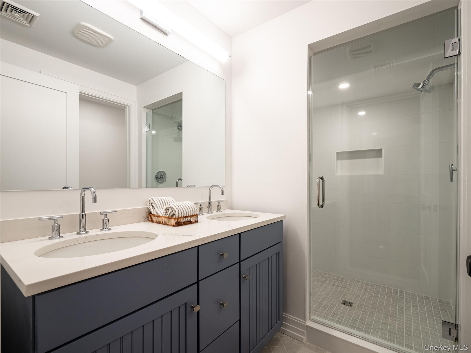 Bathroom with a shower stall and double vanity