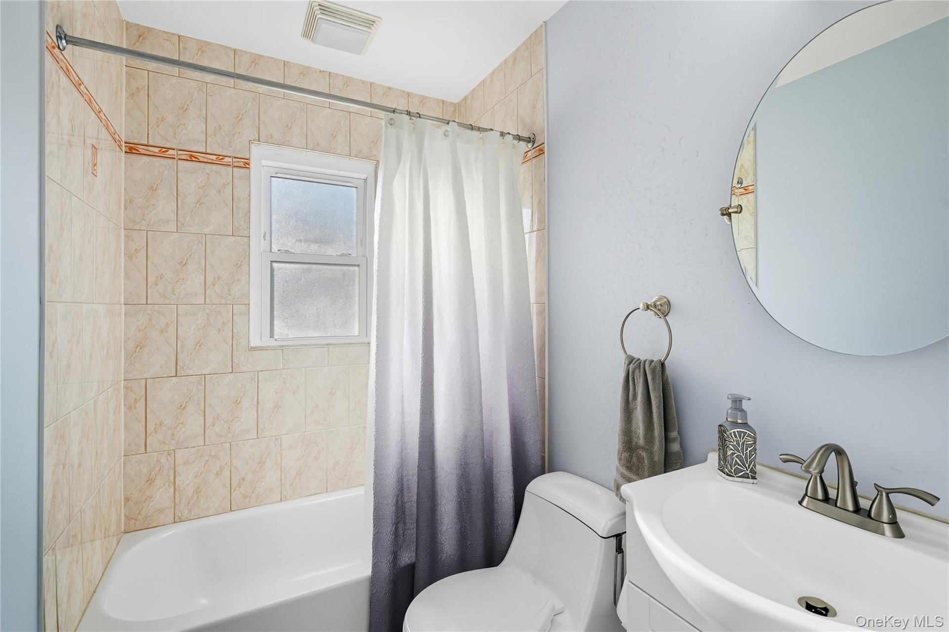 Bathroom with shower / bath combo and vanity