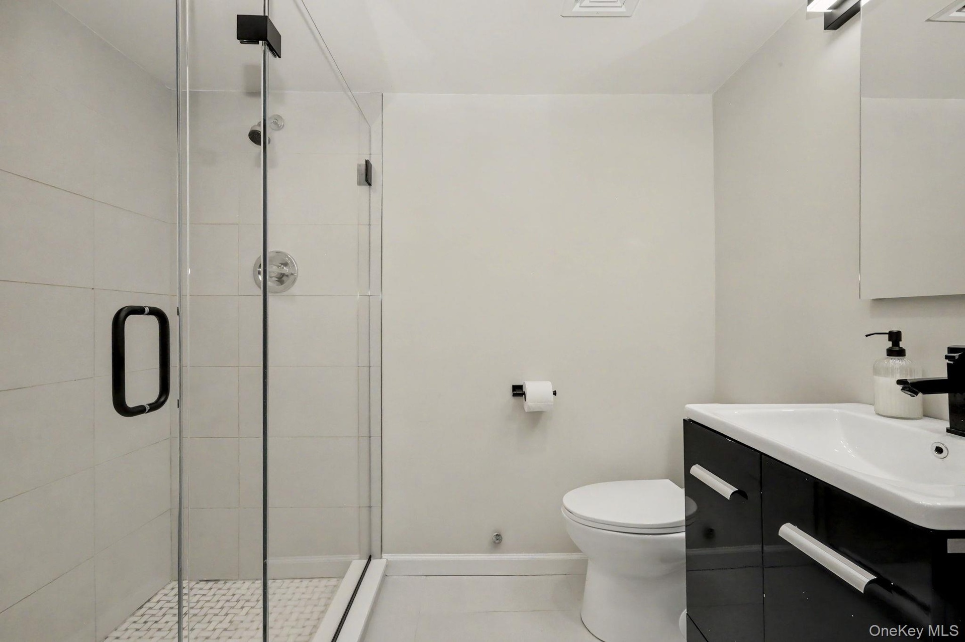 The newly renovated primary bathroom offers a fresh, sophisticated aesthetic with beautifully selected finishes.
