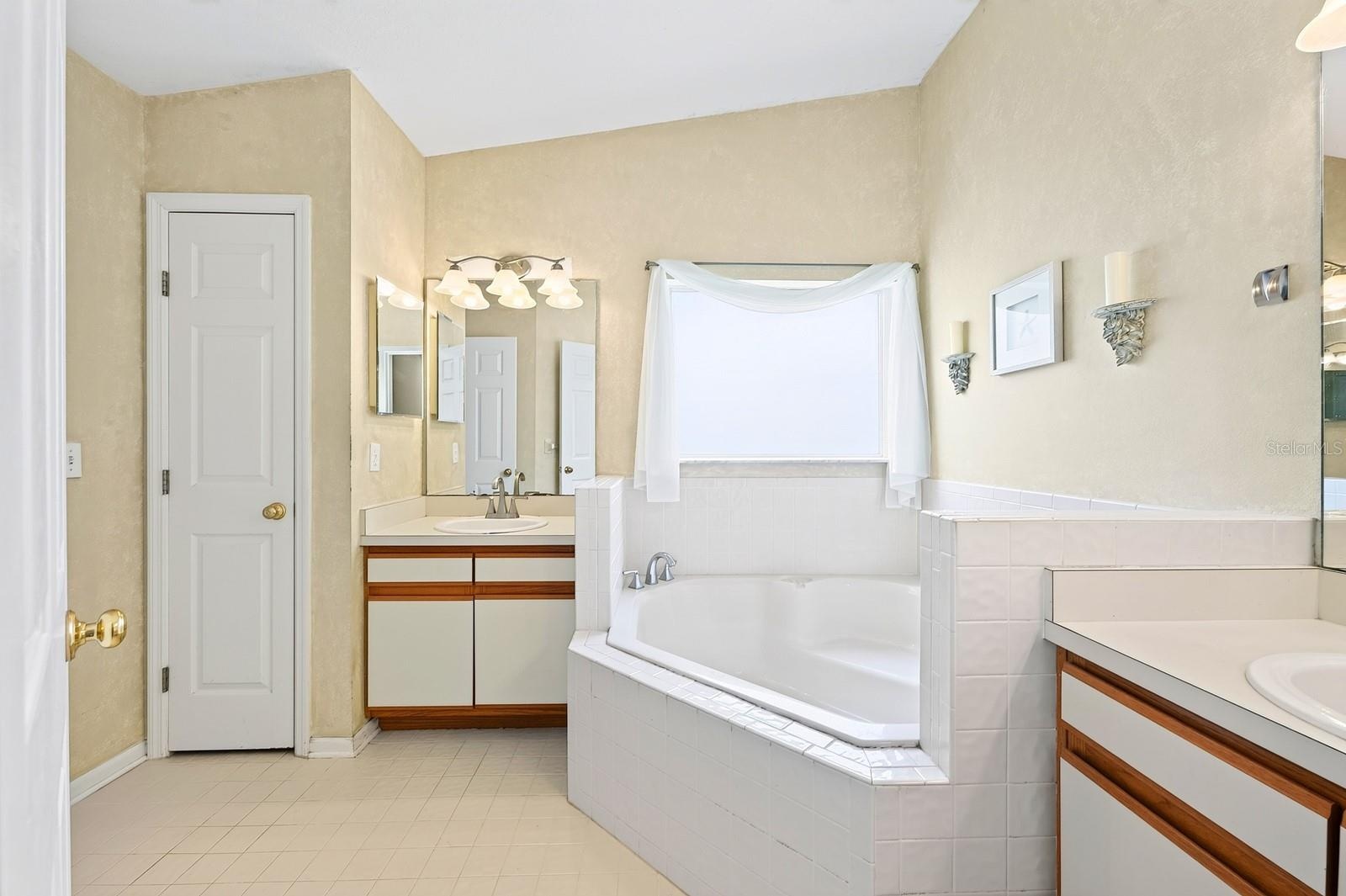 The Primary en suite boasts DUAL CLOSETS, including a WALK-IN, along with a private en-suite bath featuring dual vanities, GARDEN TUB and step-in show