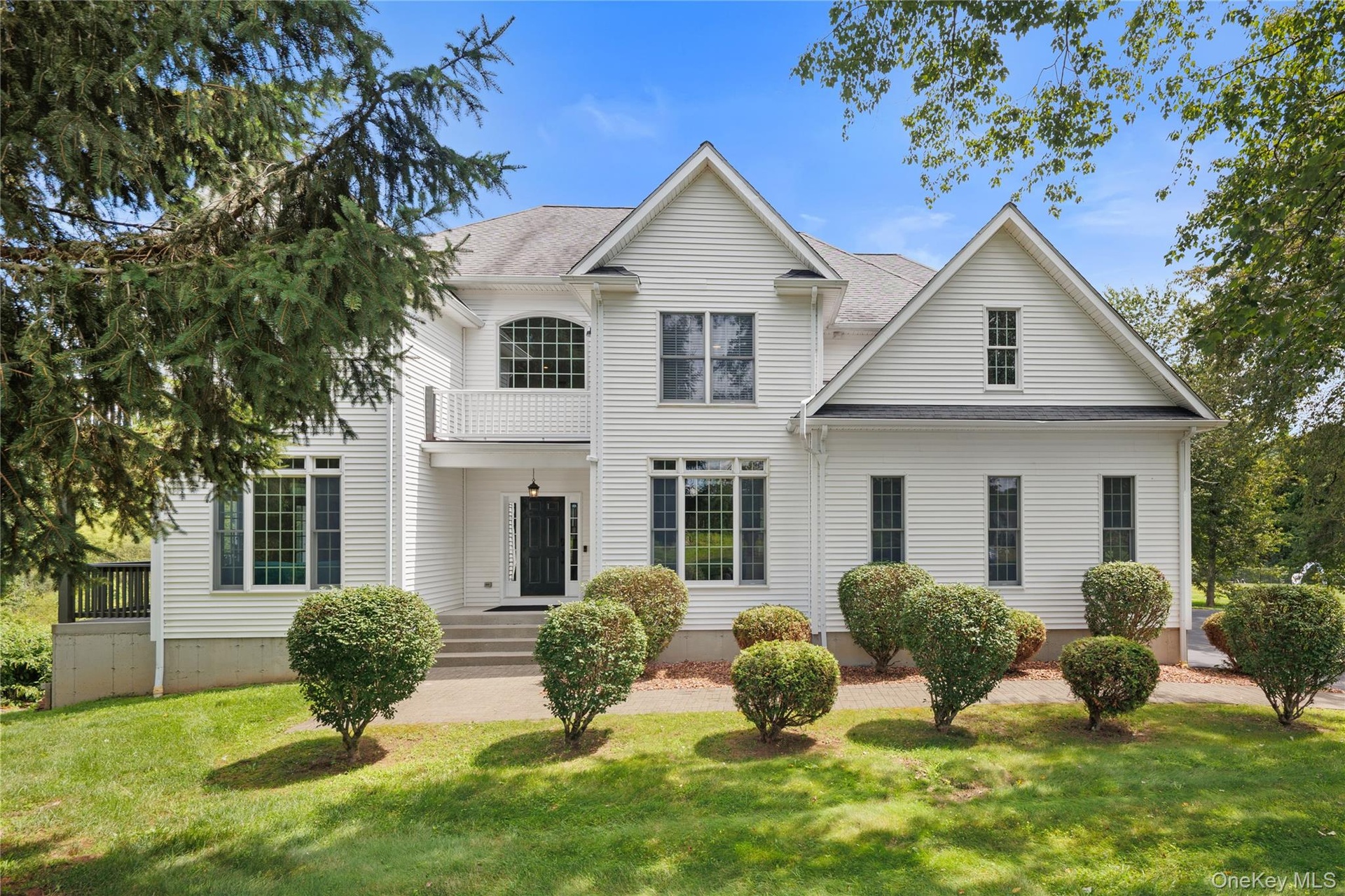 Impressive Colonial-style residence showcasing timeless elegance, exceptional architectural detail, and a grand sense of scale. The classic white exte