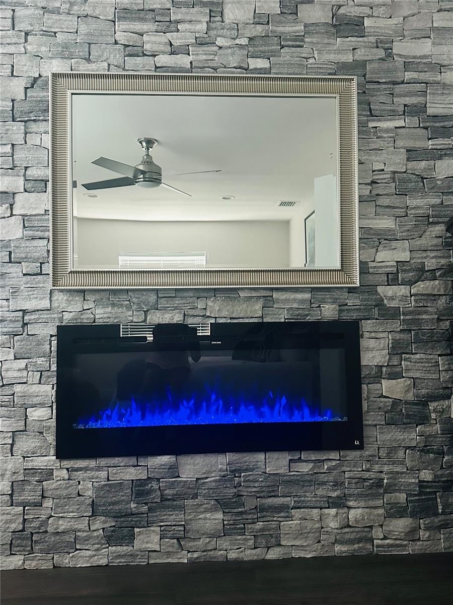 Primary bedroom stone accent wall with fireplace