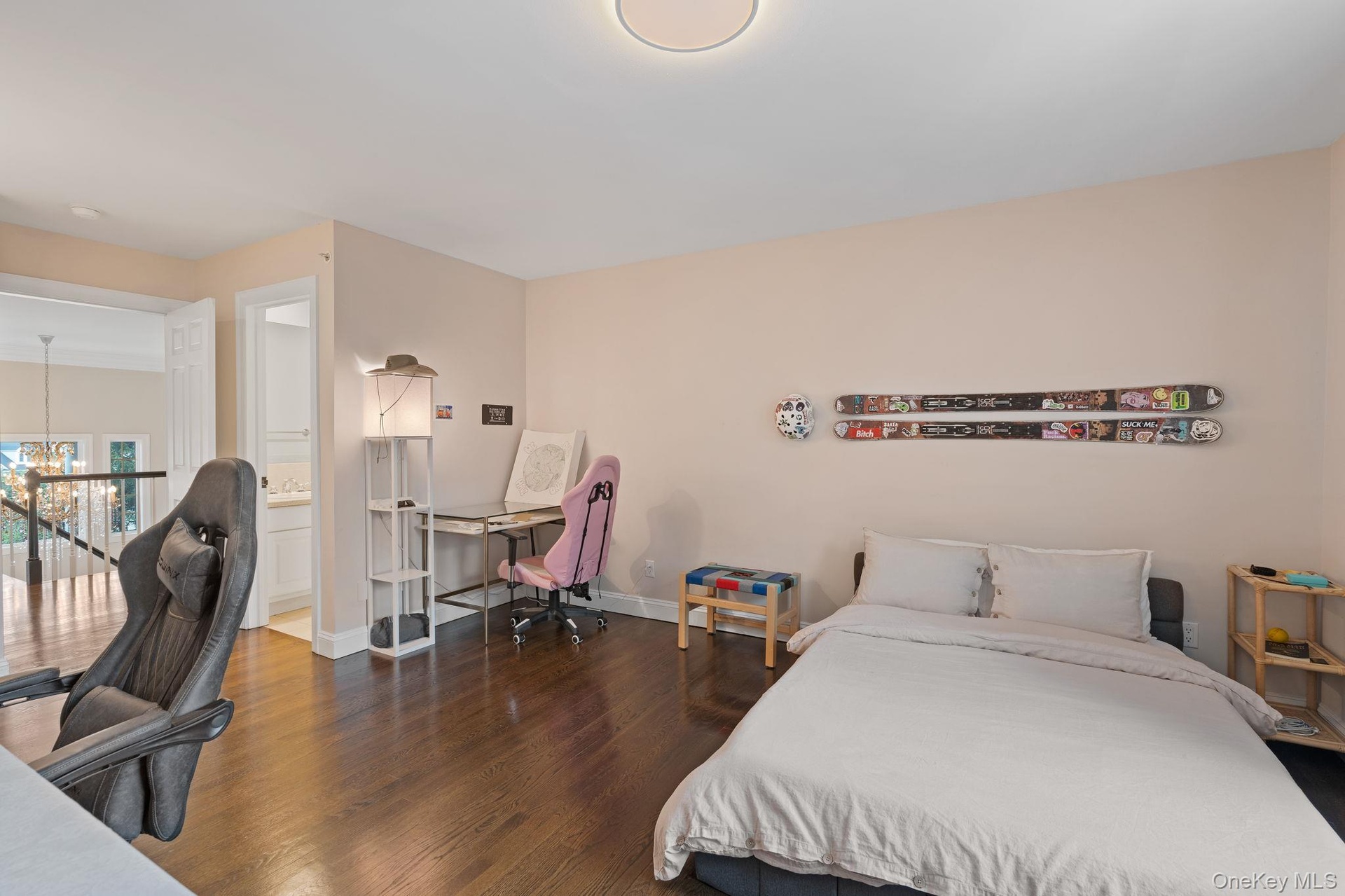 Bedroom with an office area, dark wood finished floors, a chandelier, and ensuite bathroom