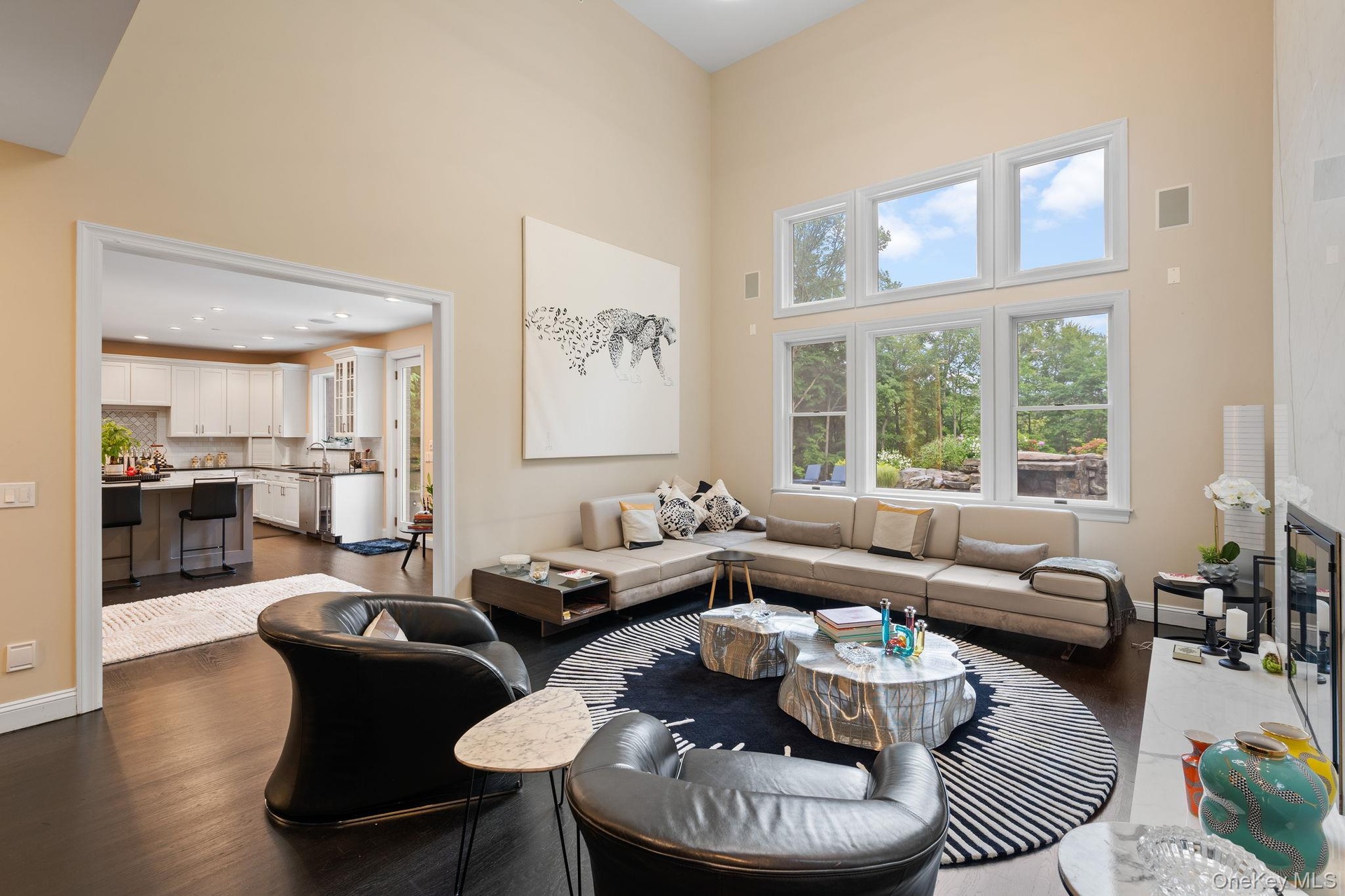 Living room with a towering ceiling, dark wood-style flooring, and recessed lighting