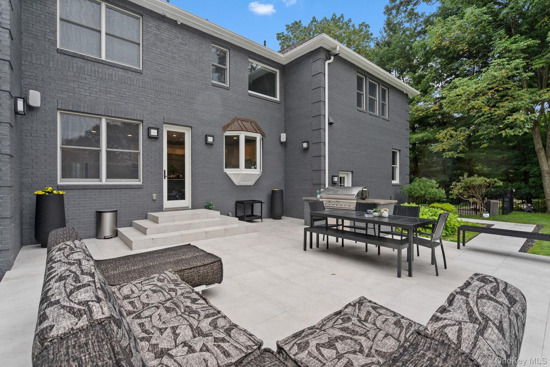 Back of property with a patio, outdoor dining space, and brick siding