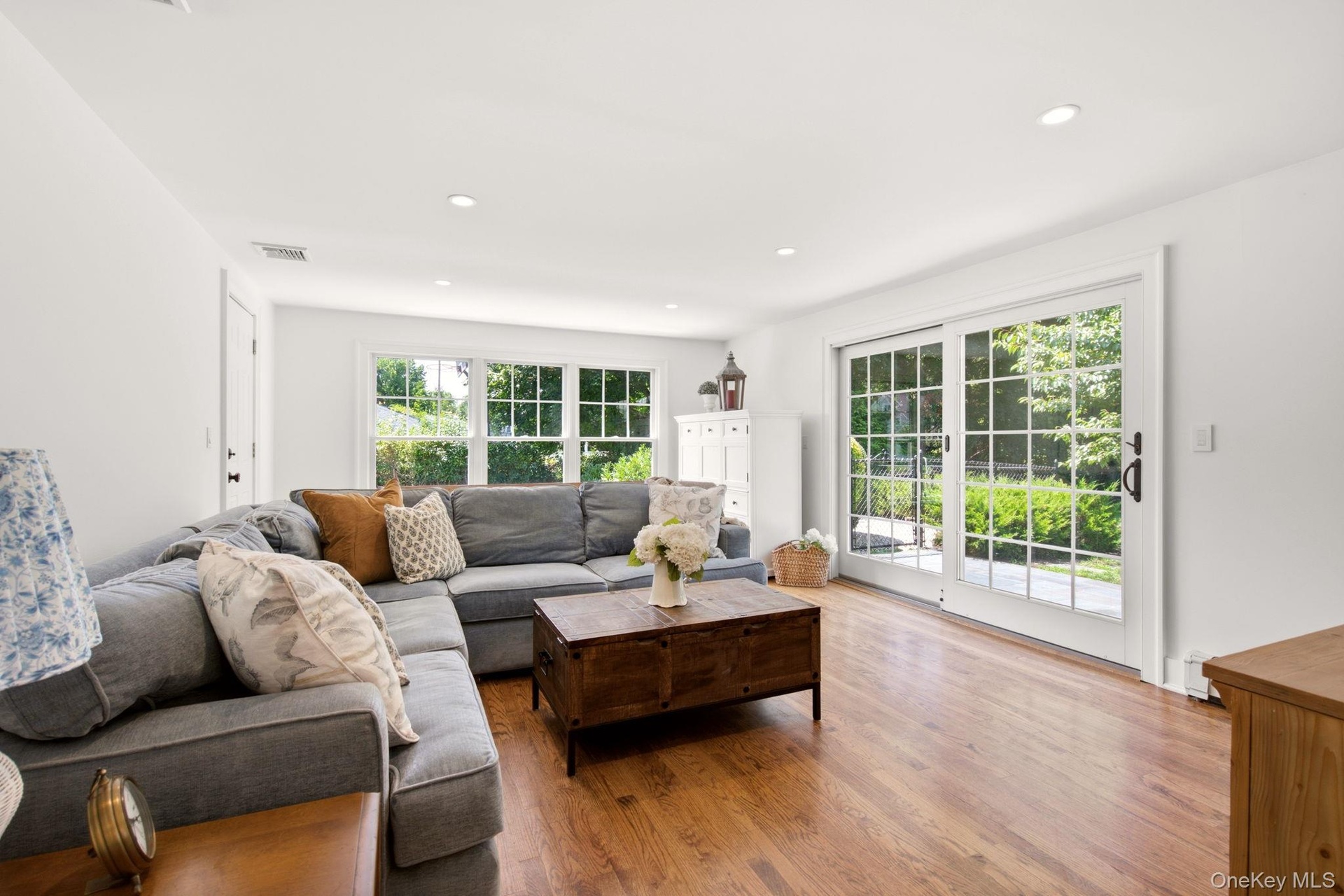 Sliding Doors open to a blue stone patio overlooking the yard.