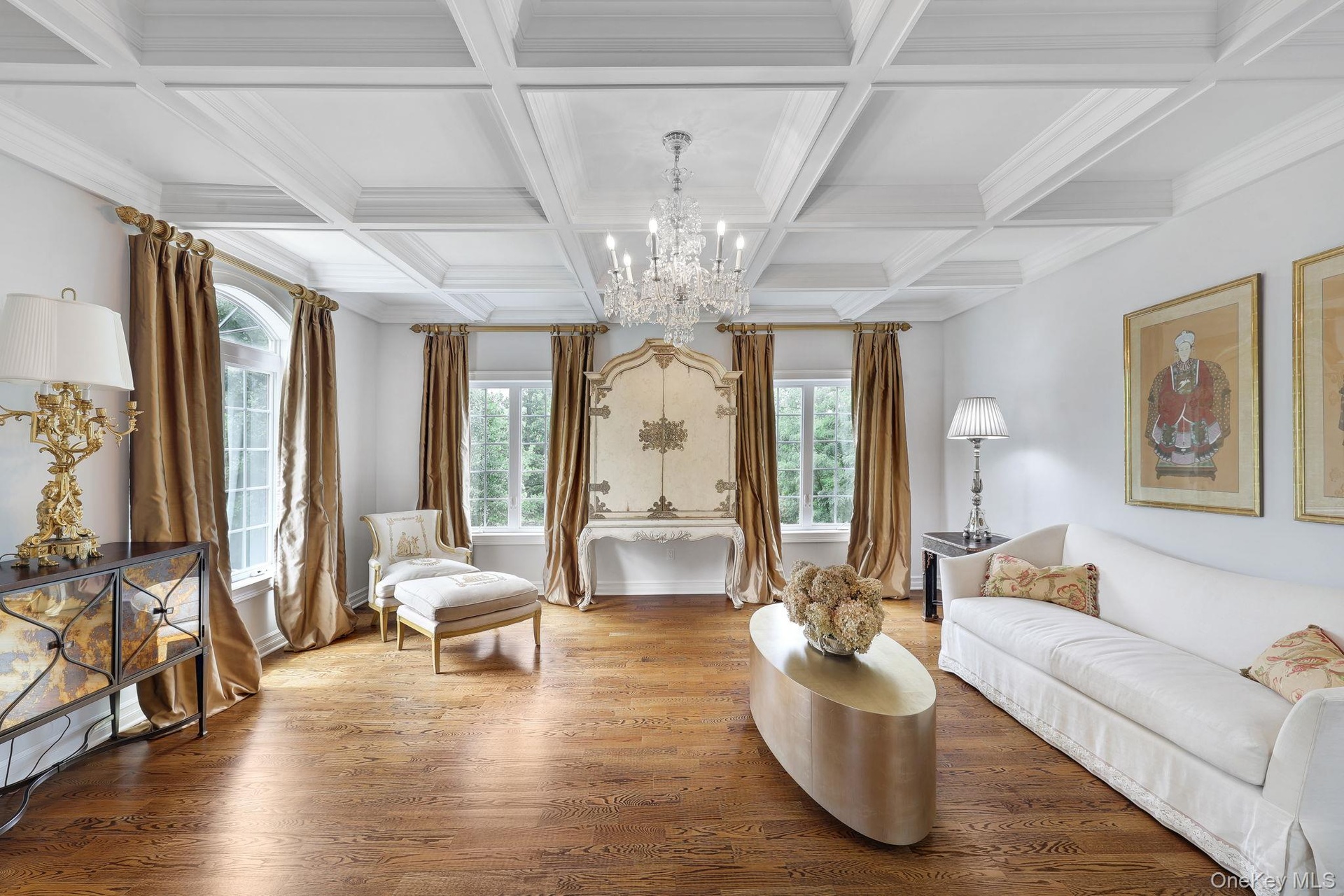 Coffered ceiling with a crystal chandelier, wood-finish flooring, and multiple windows