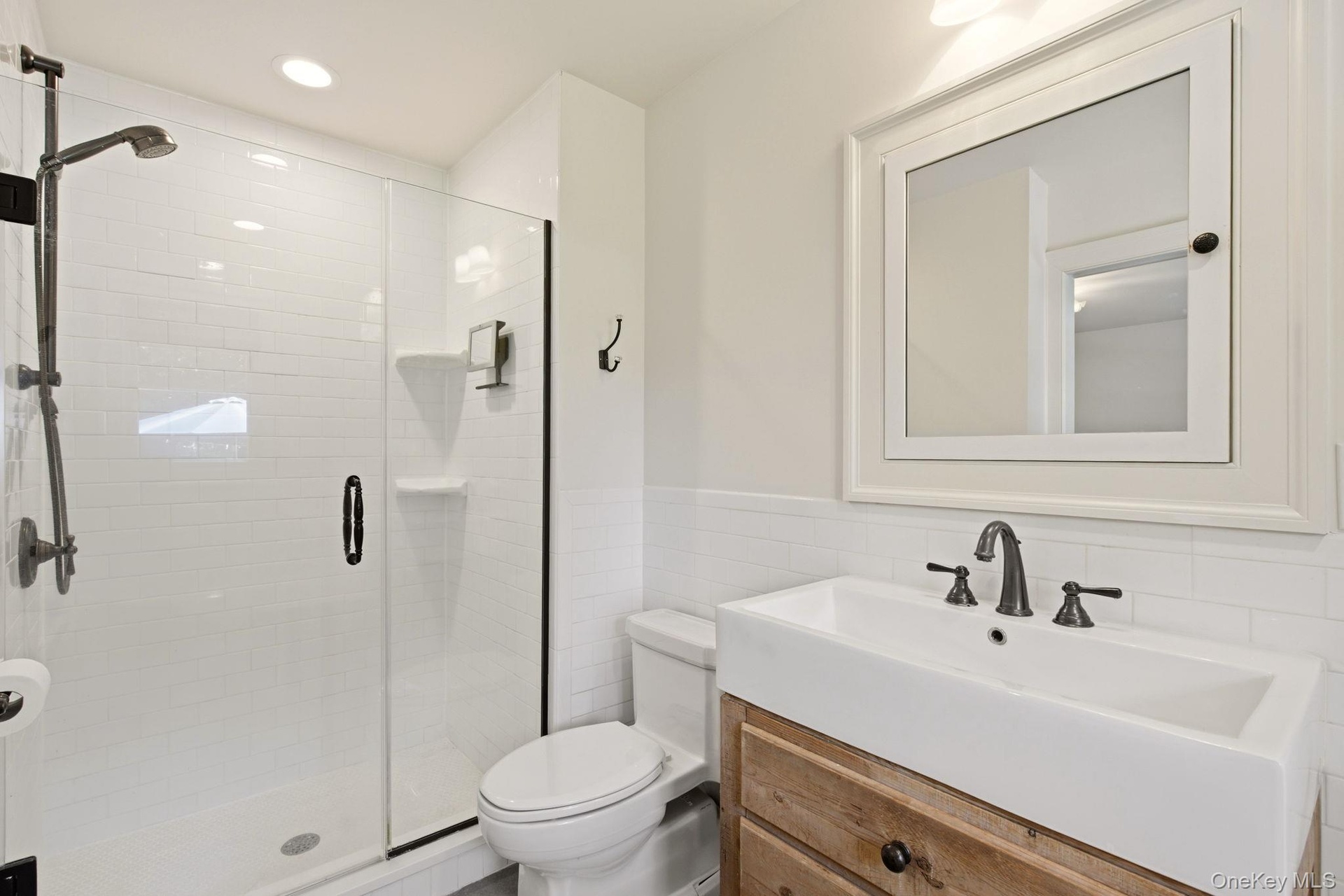 Classically Updated Bathroom with shower and farm-style vanity.