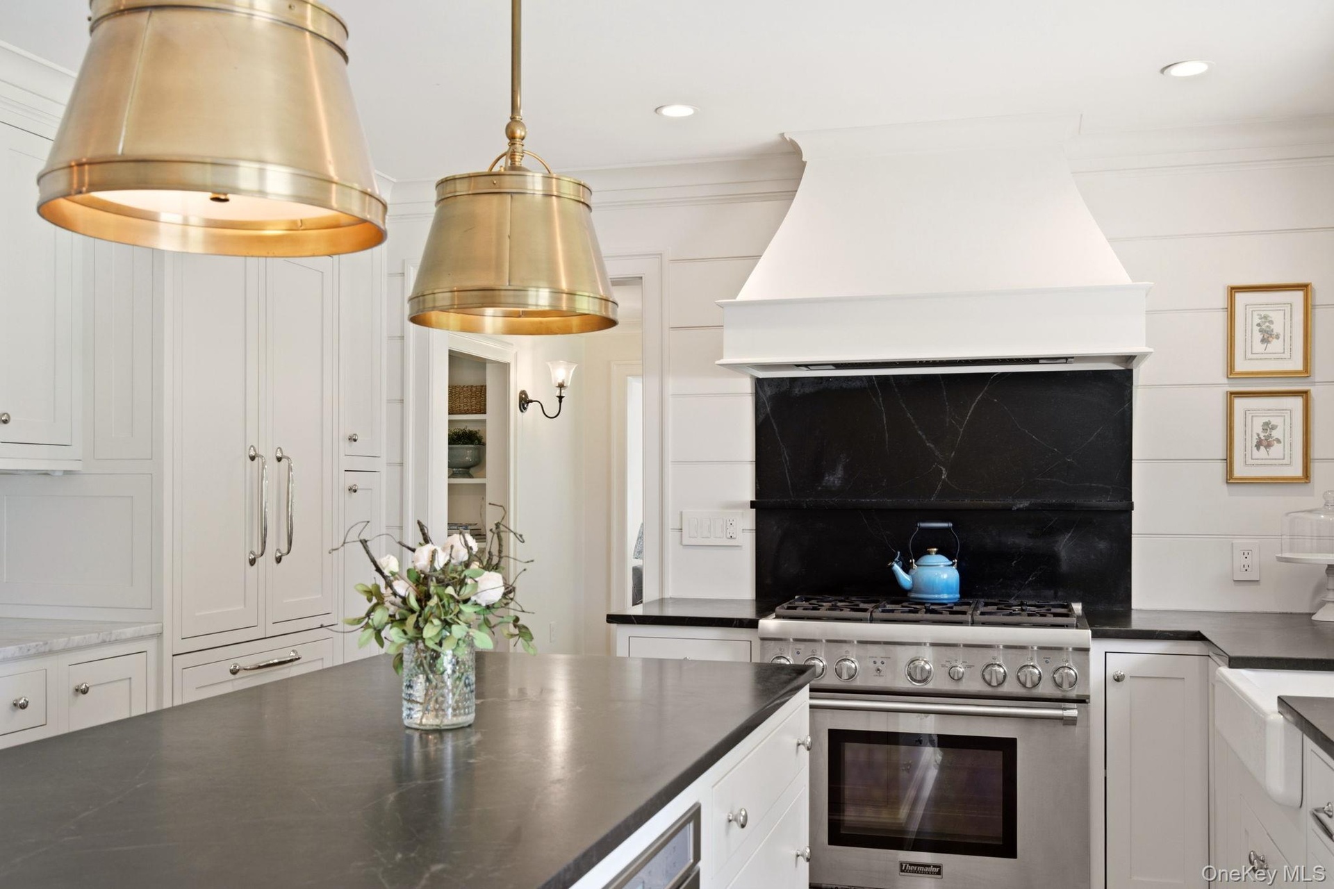 Thermador gas range with custom range hood.