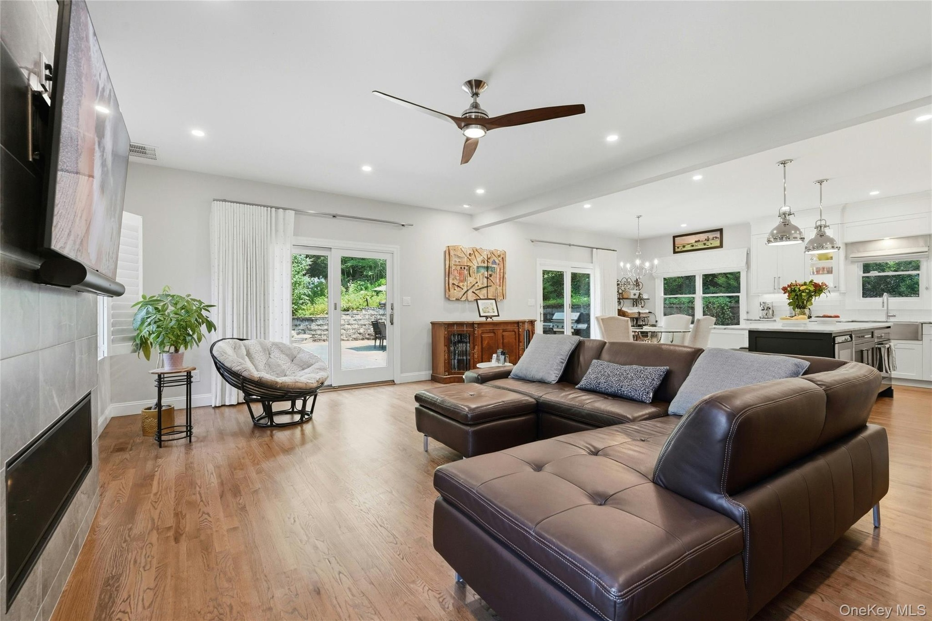 Open-concept living space featuring hardwood flooring, and floor-to-ceiling windows with natural light