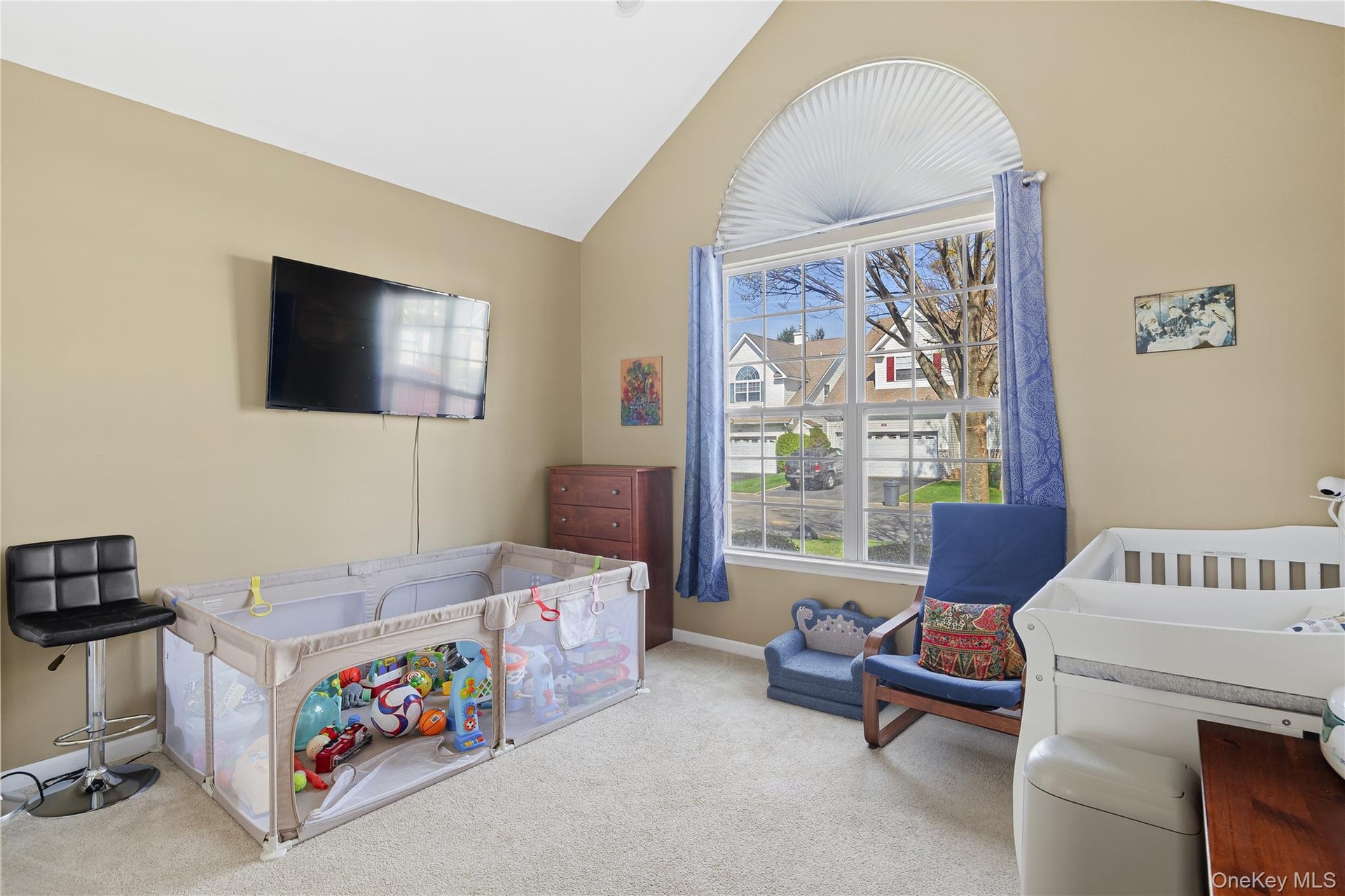 First Floor ,vaulted ceiling, arched window with blind, carpeted flooring, and neutral wall tones