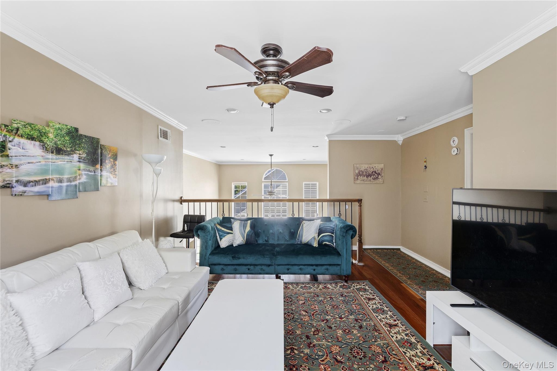 Recessed lighting, crown molding, ceiling fan, wood-finish flooring, and a second-story railing