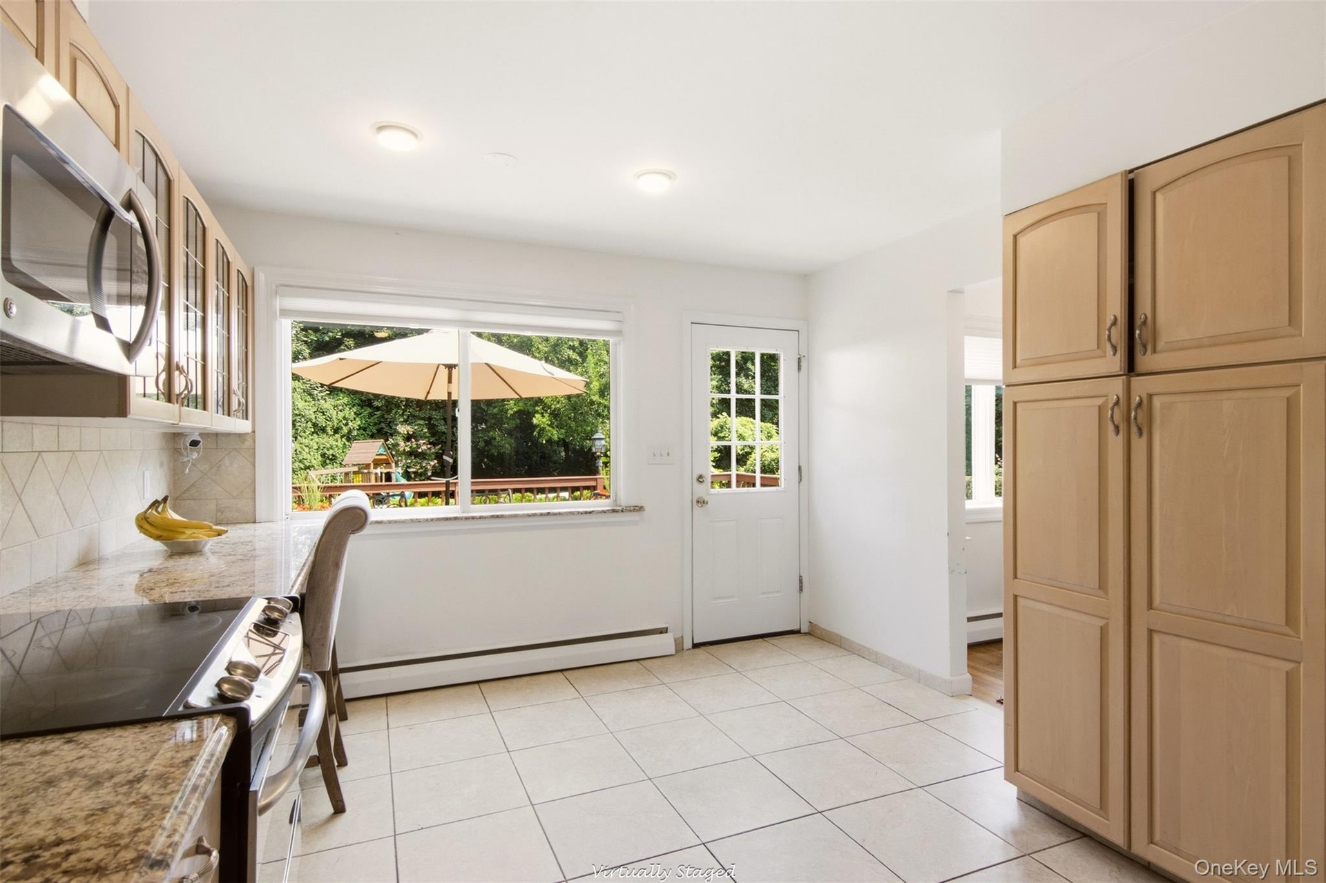Kitchen featuring light wood-finish cabinetry, tile flooring, and granite-look countertops