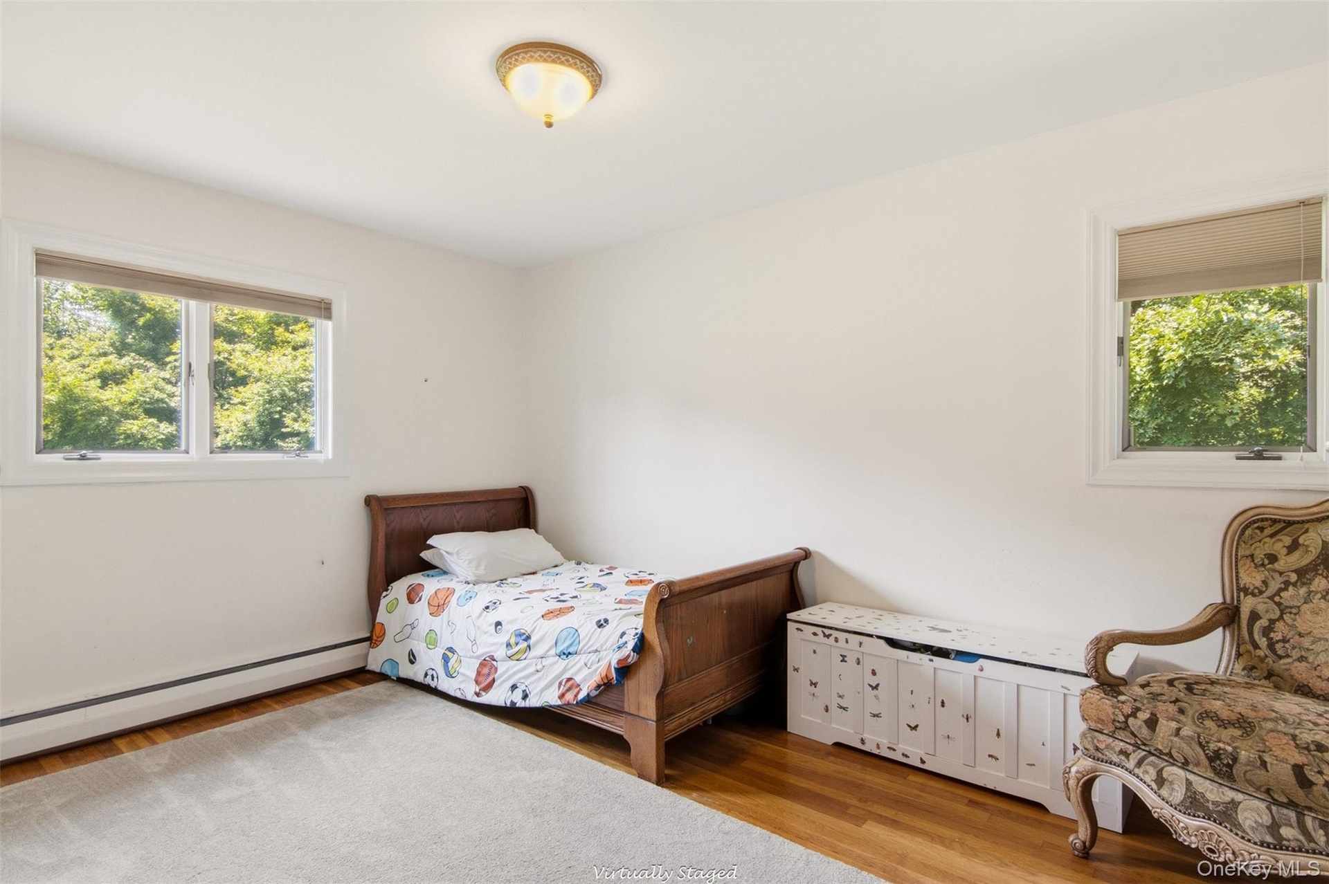 Natural light from multiple windows, wood-finish flooring, and a flush mount ceiling light fixture