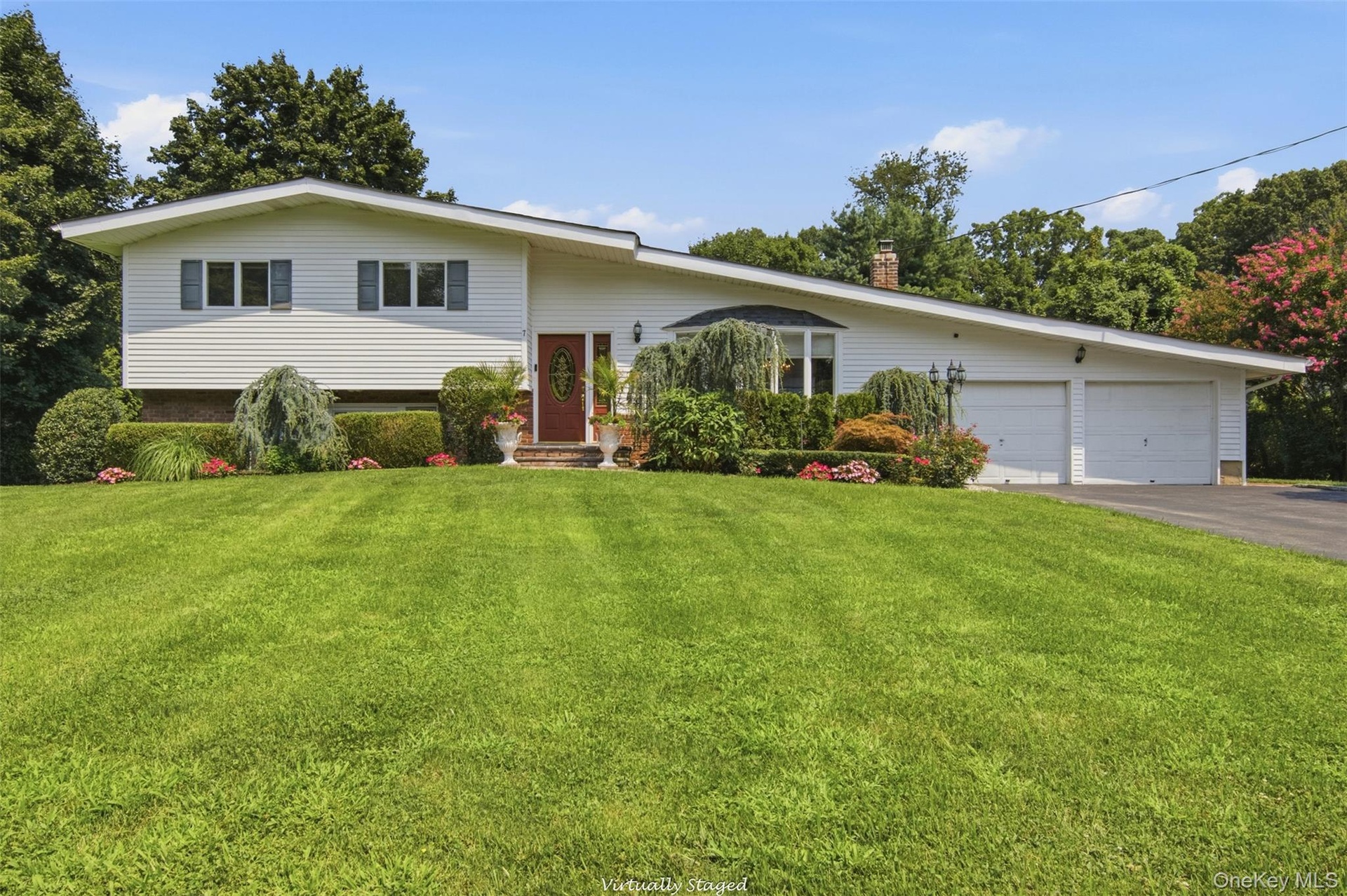 White siding exterior with a red entry door, bay window, and attached two-car garage
