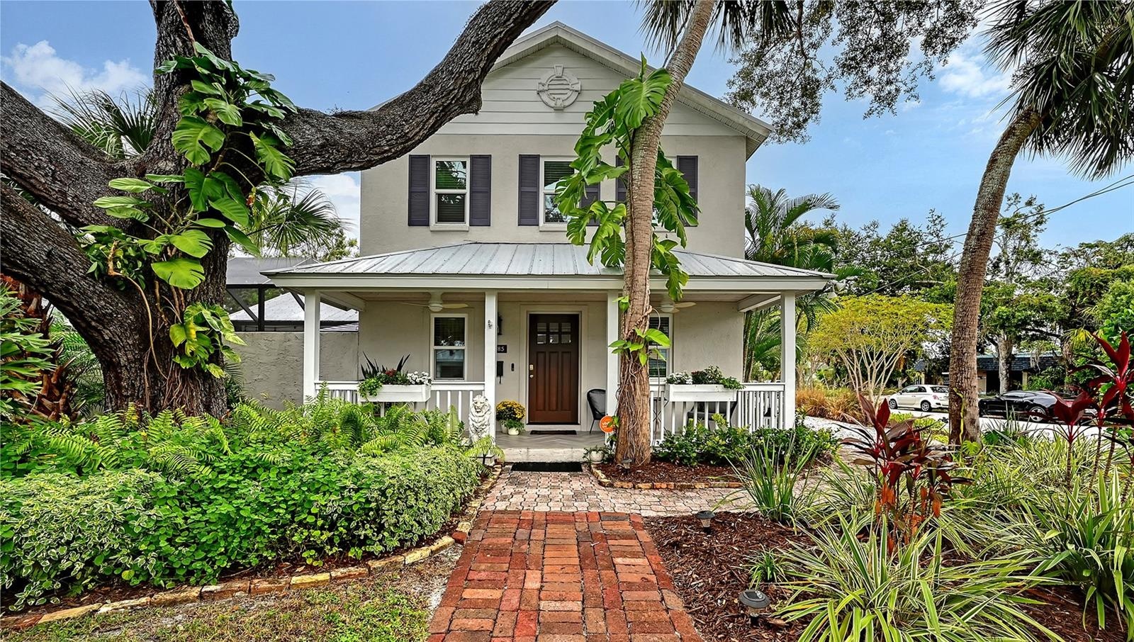 Beautifully landscaped Key West–inspired residence welcomes you with timeless architectural character, mature tropical landscaping, and an impressive 