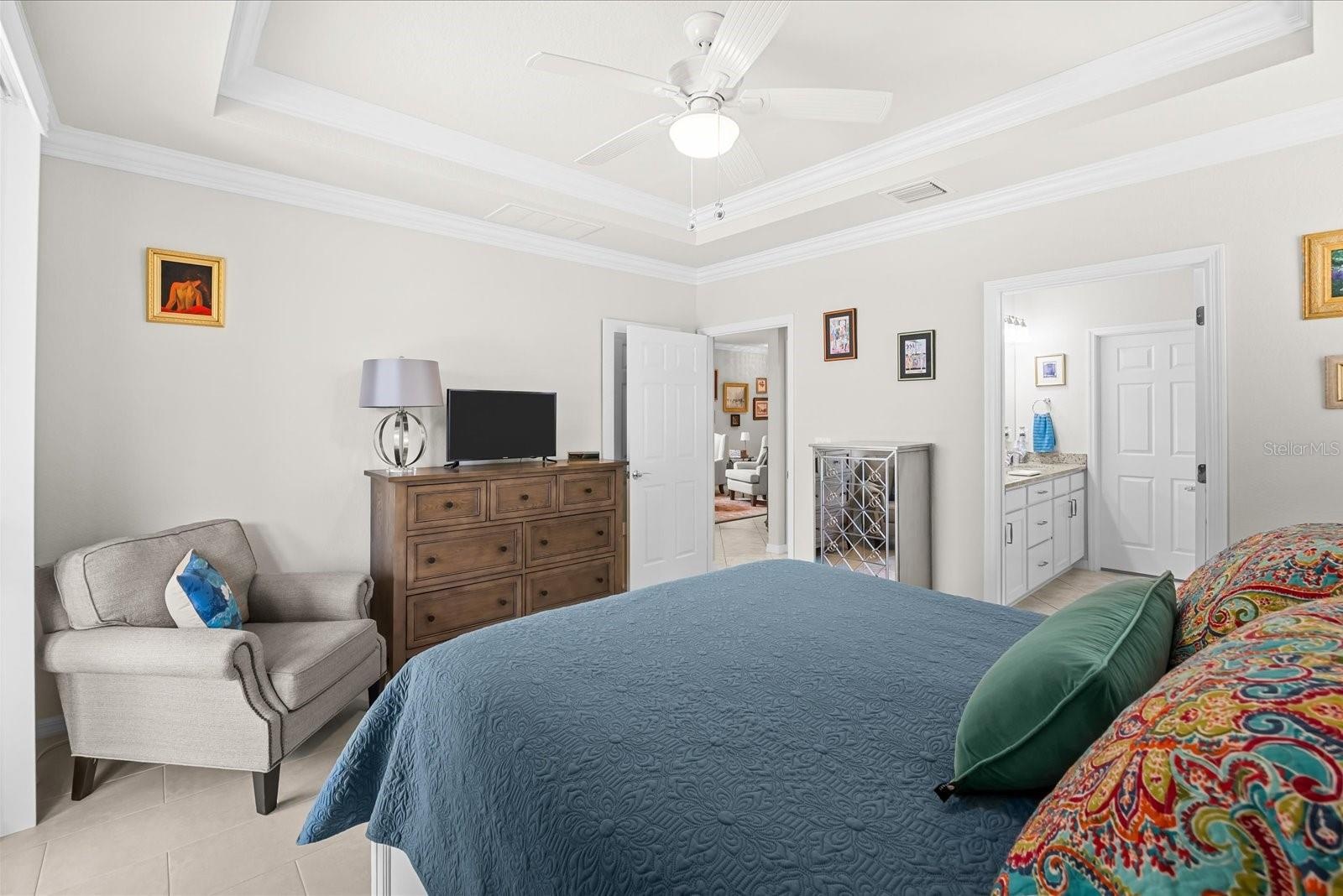 Primary Bedroom Featuring a Coffered Ceiling and Crown Molding