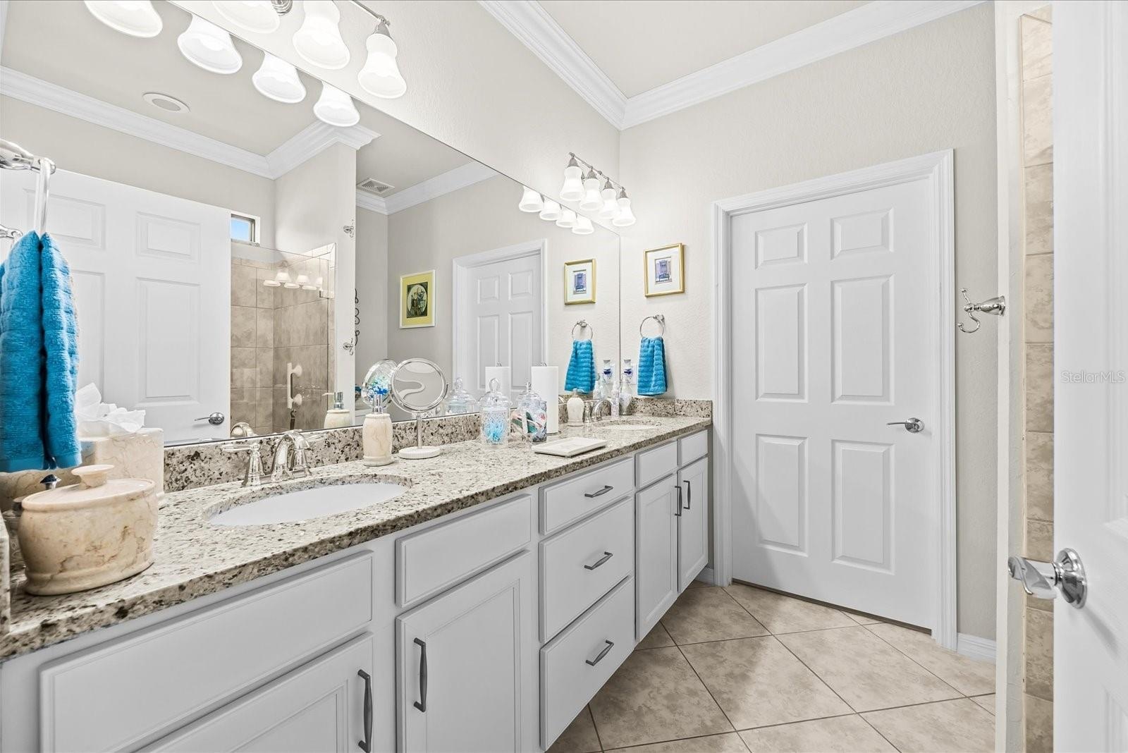 Primary Bathroom Featuring Granite Countertops and Dual Sinks